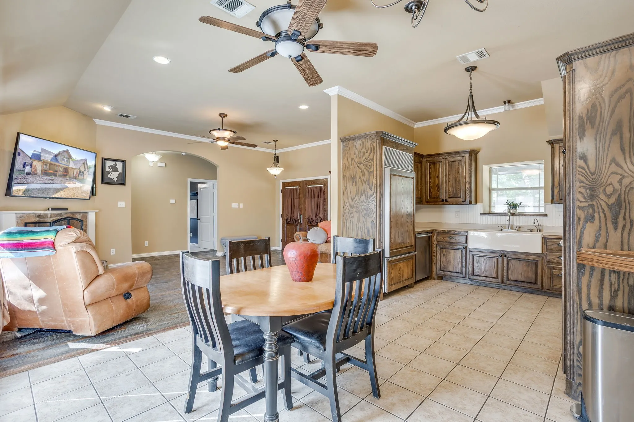 dining area is open to the living room with a view of the fireplace and pool