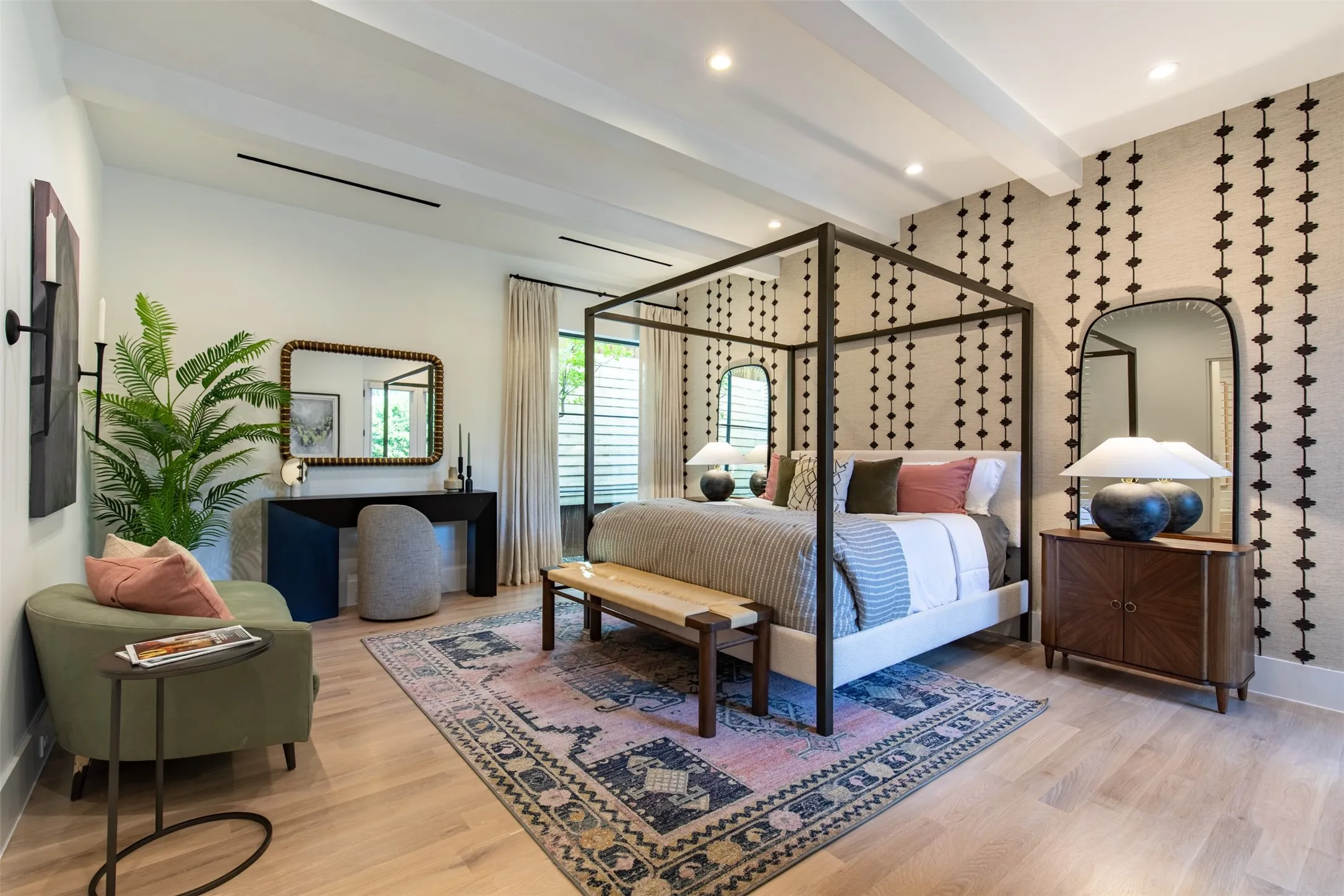 Spacious room featuring light wood-finish flooring, exposed ceiling beams, a patterned accent wall, and recessed lighting
