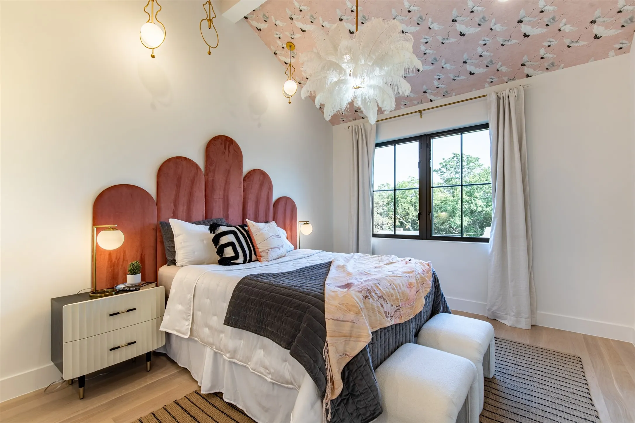 Vaulted ceiling with decorative wallpaper and a central chandelier