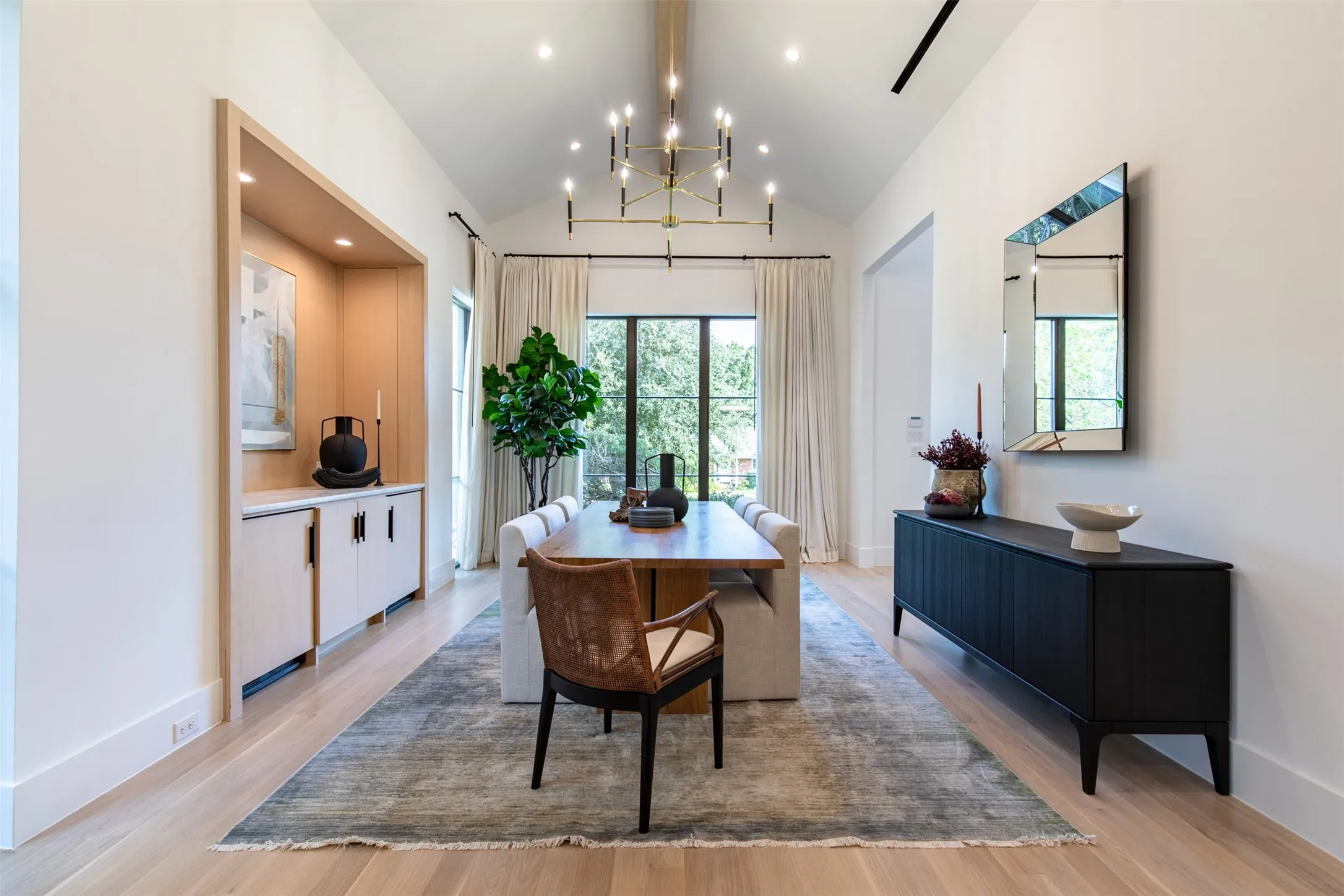 Dining area featuring a vaulted ceiling with a linear chandelier, recessed lighting, and wood-finish flooring