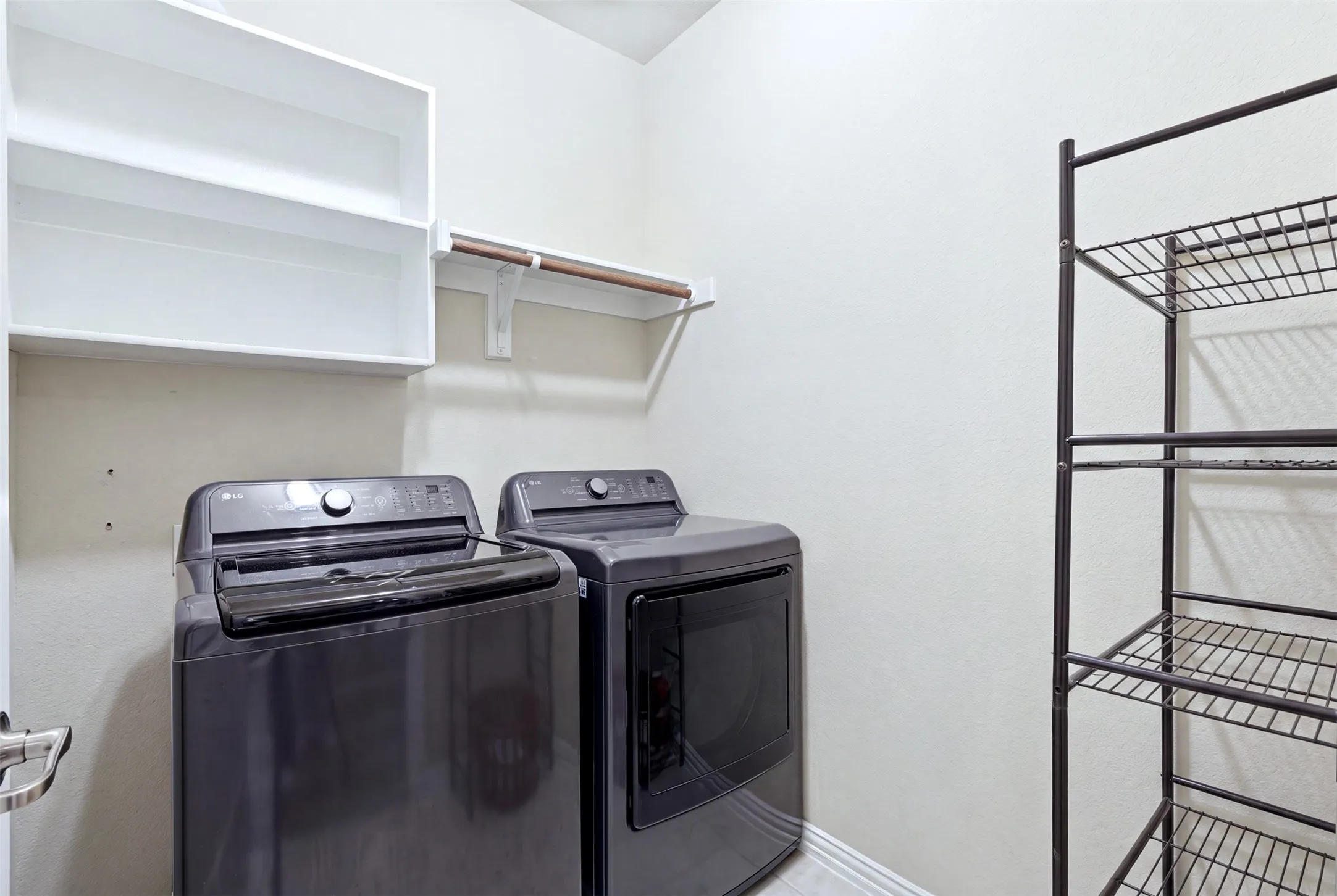 White wall-mounted shelving, built-in clothing rod, and light-toned walls