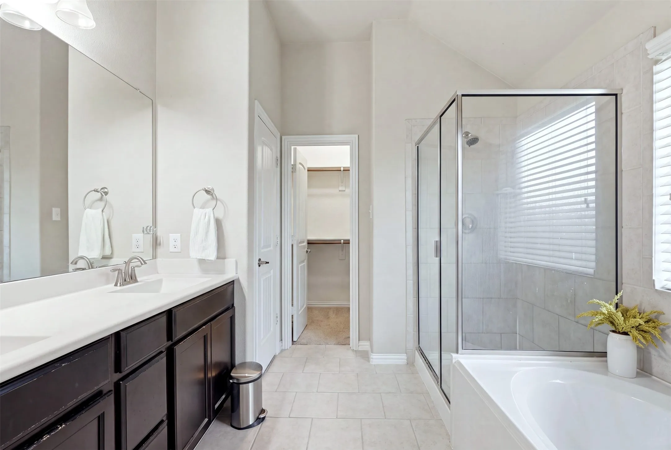 Dual vanity with white countertop, framed mirror, and brushed nickel fixtures