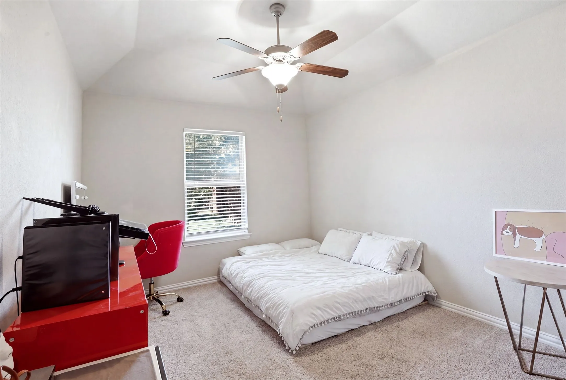 Vaulted ceiling with an attached ceiling fan, single window with blinds, and carpeted flooring