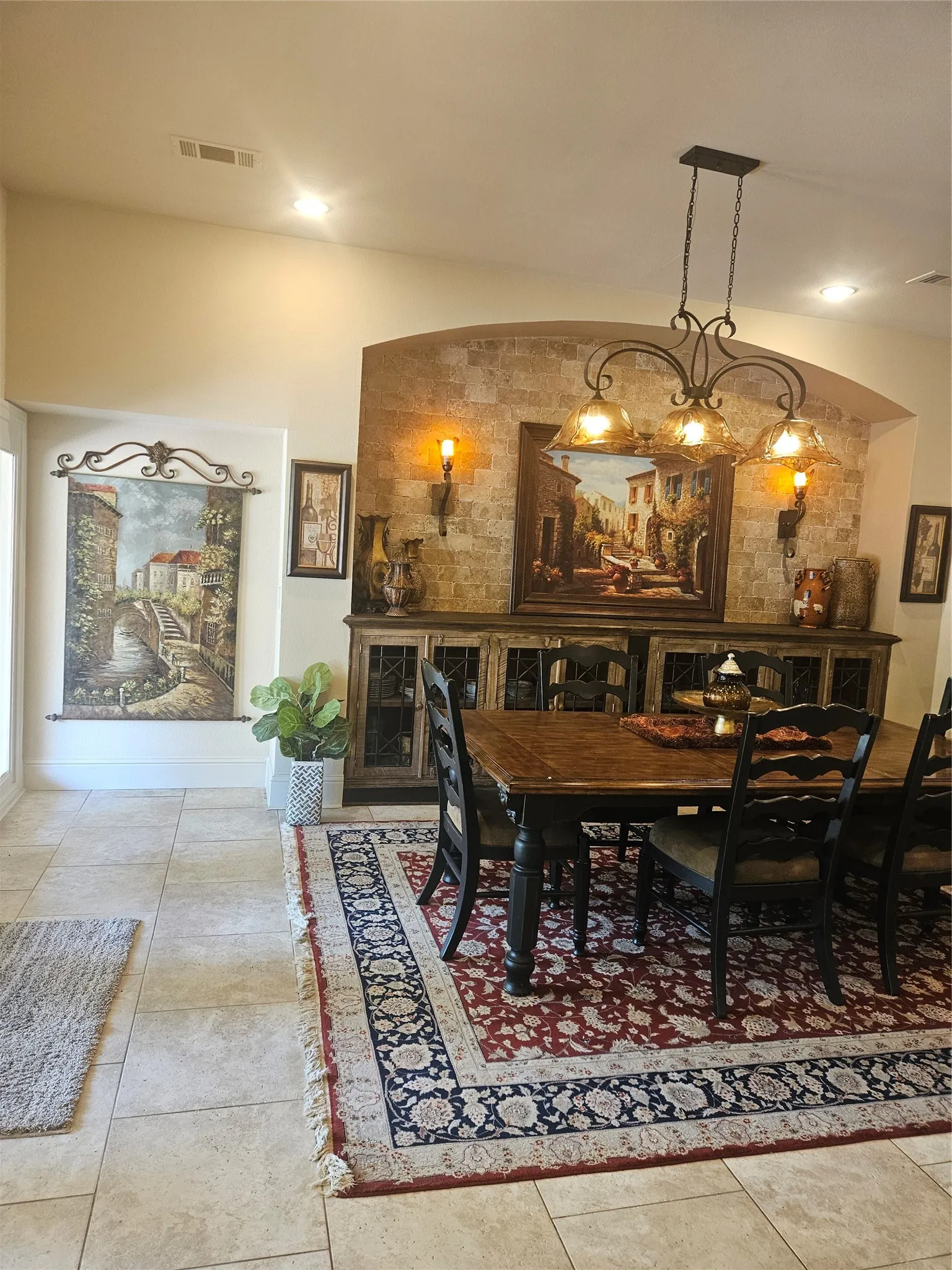 Dining area featuring a decorative stone-clad archway