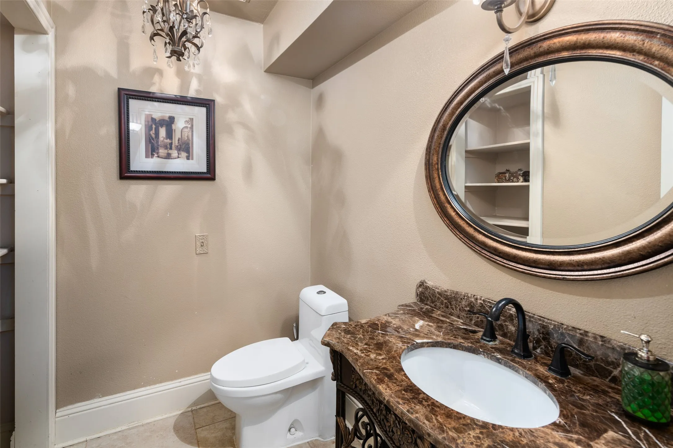 Half bath featuring toilet, vanity, tile patterned flooring, and baseboards