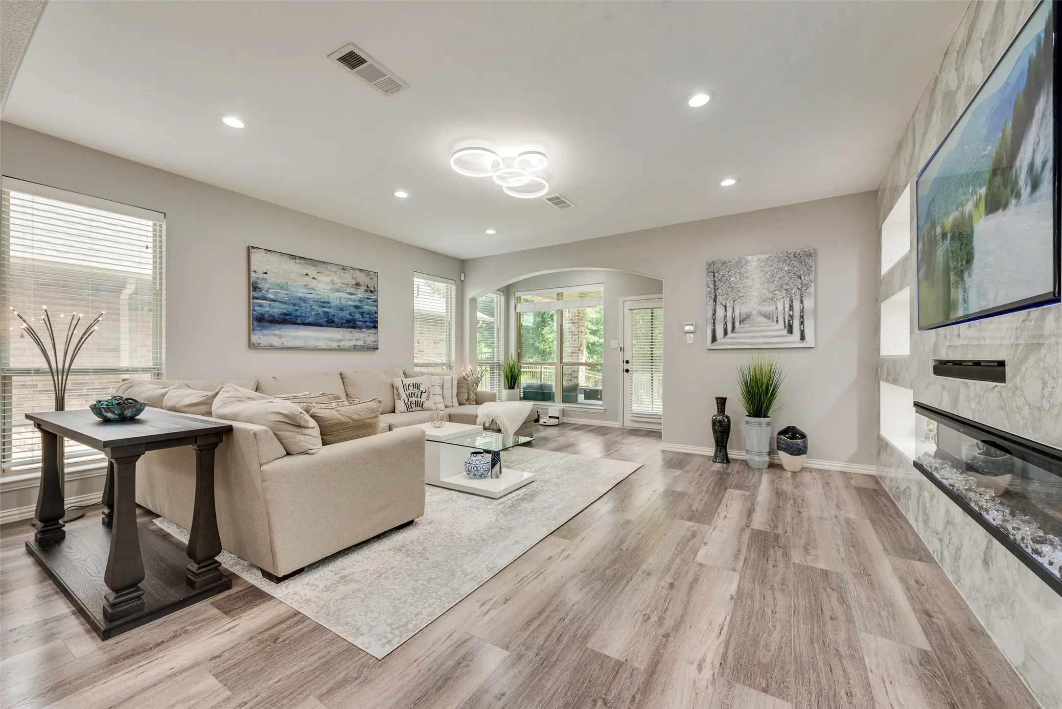 Spacious living area featuring wood-finish flooring, recessed lighting, and a contemporary ceiling fixture