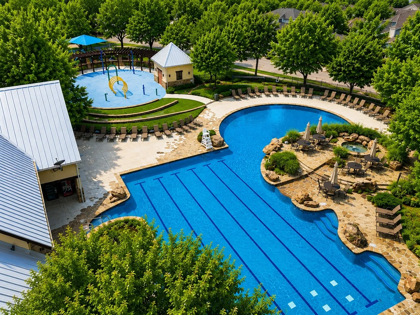 Resort-style pool area featuring a multi-lane lap pool, a freeform leisure pool, and a separate splash pad