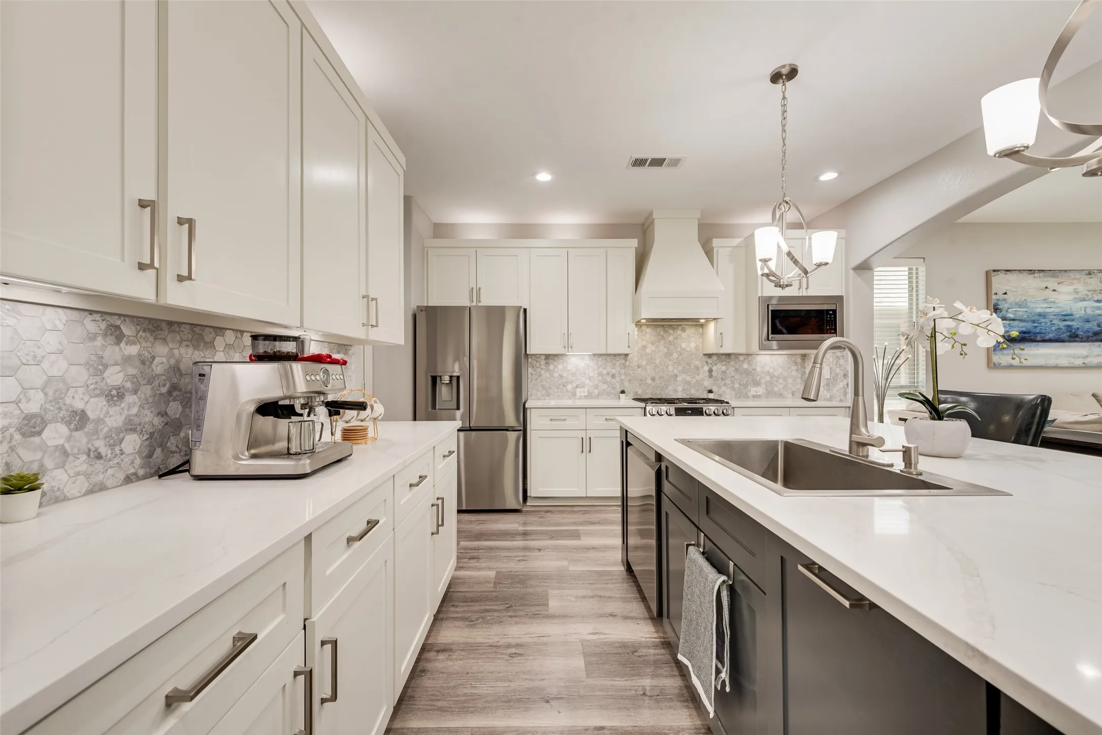 Modern kitchen featuring white shaker cabinetry and a contrasting dark gray island