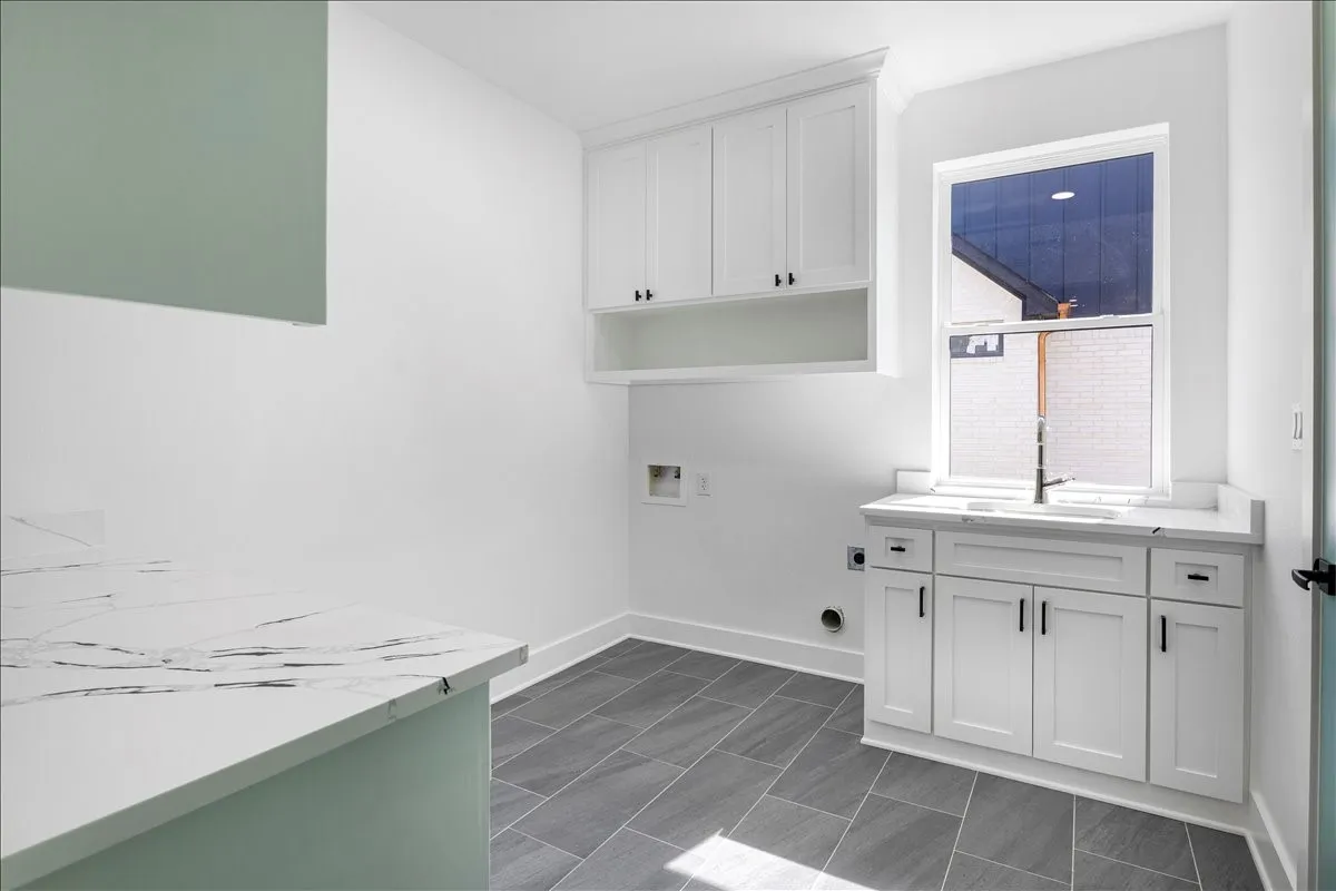 White shaker-style cabinetry, a built-in sink with a matte black faucet, and white countertops