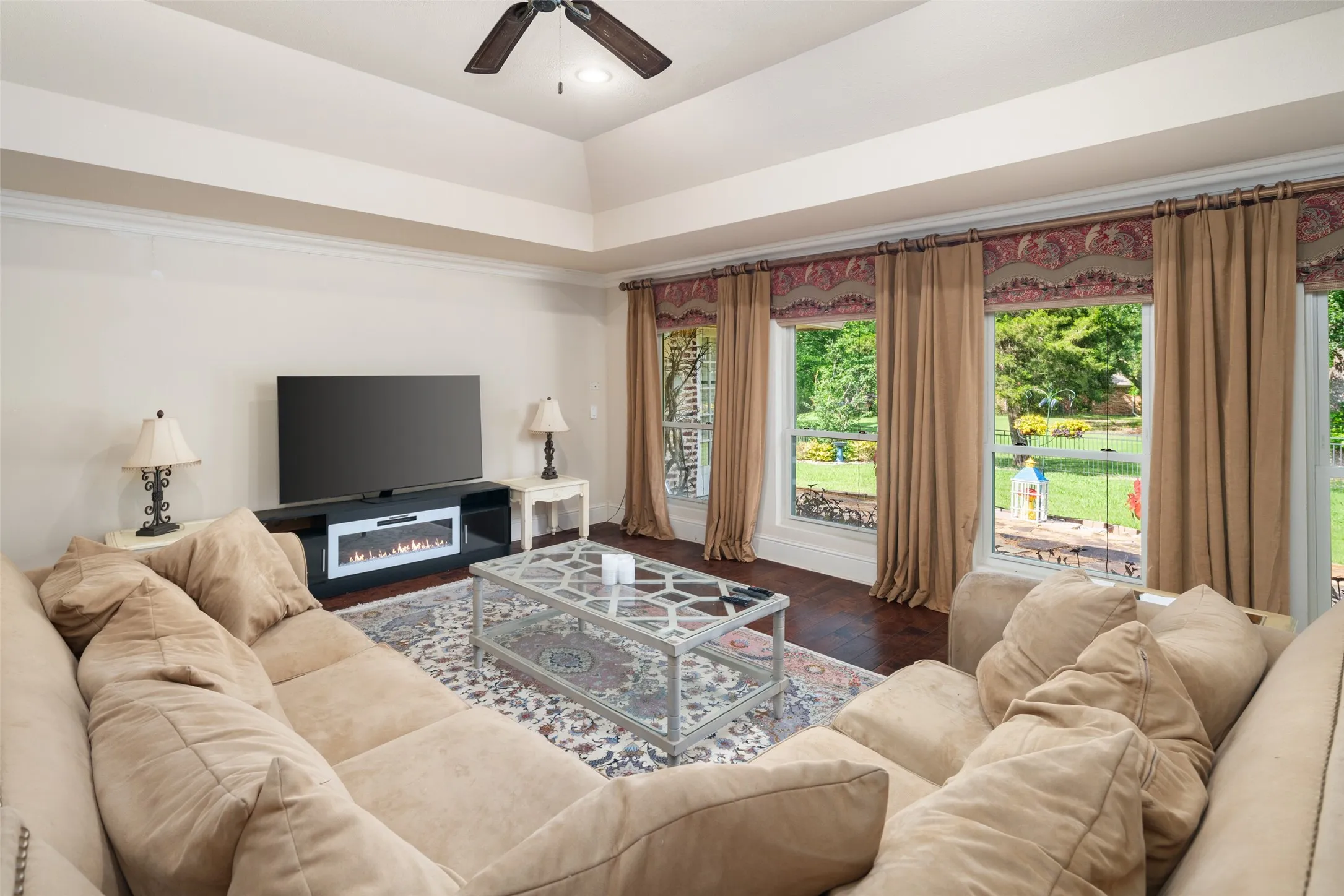 Living area featuring a ceiling fan, wood finished floors, and baseboards