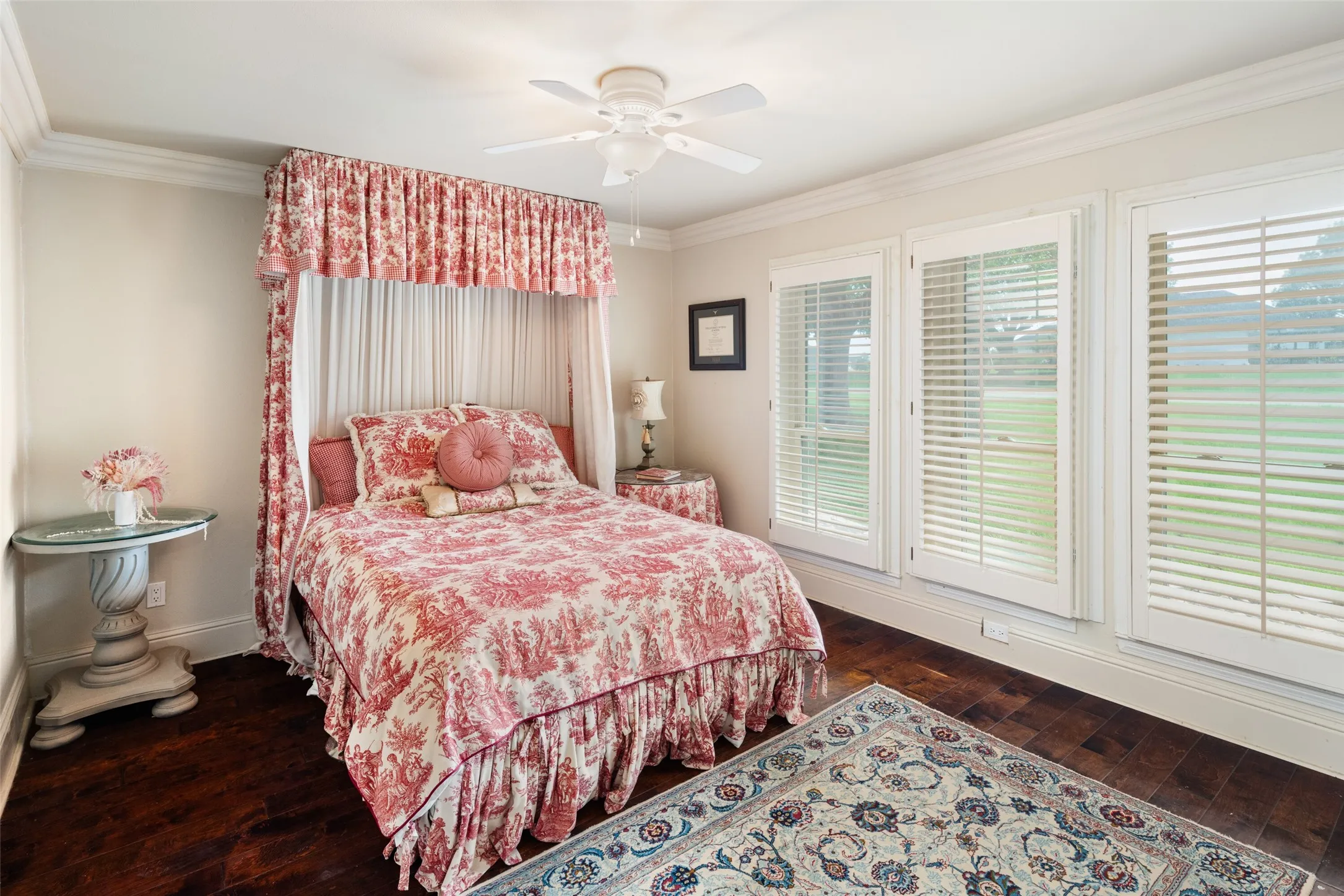 Bedroom featuring crown molding, dark wood finished floors, baseboards, and ceiling fan