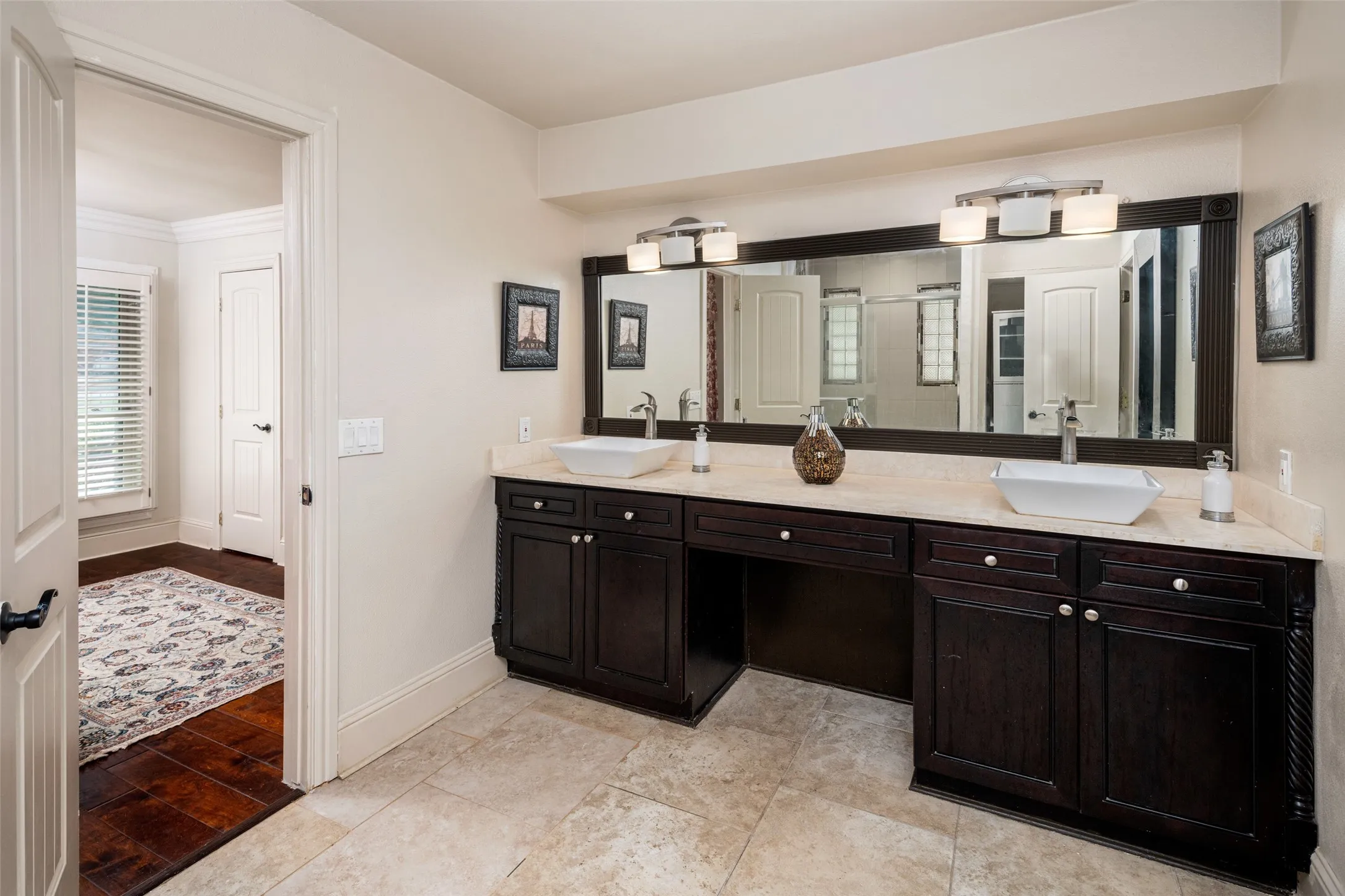 Bathroom with double vanity, a shower stall, and ornamental molding