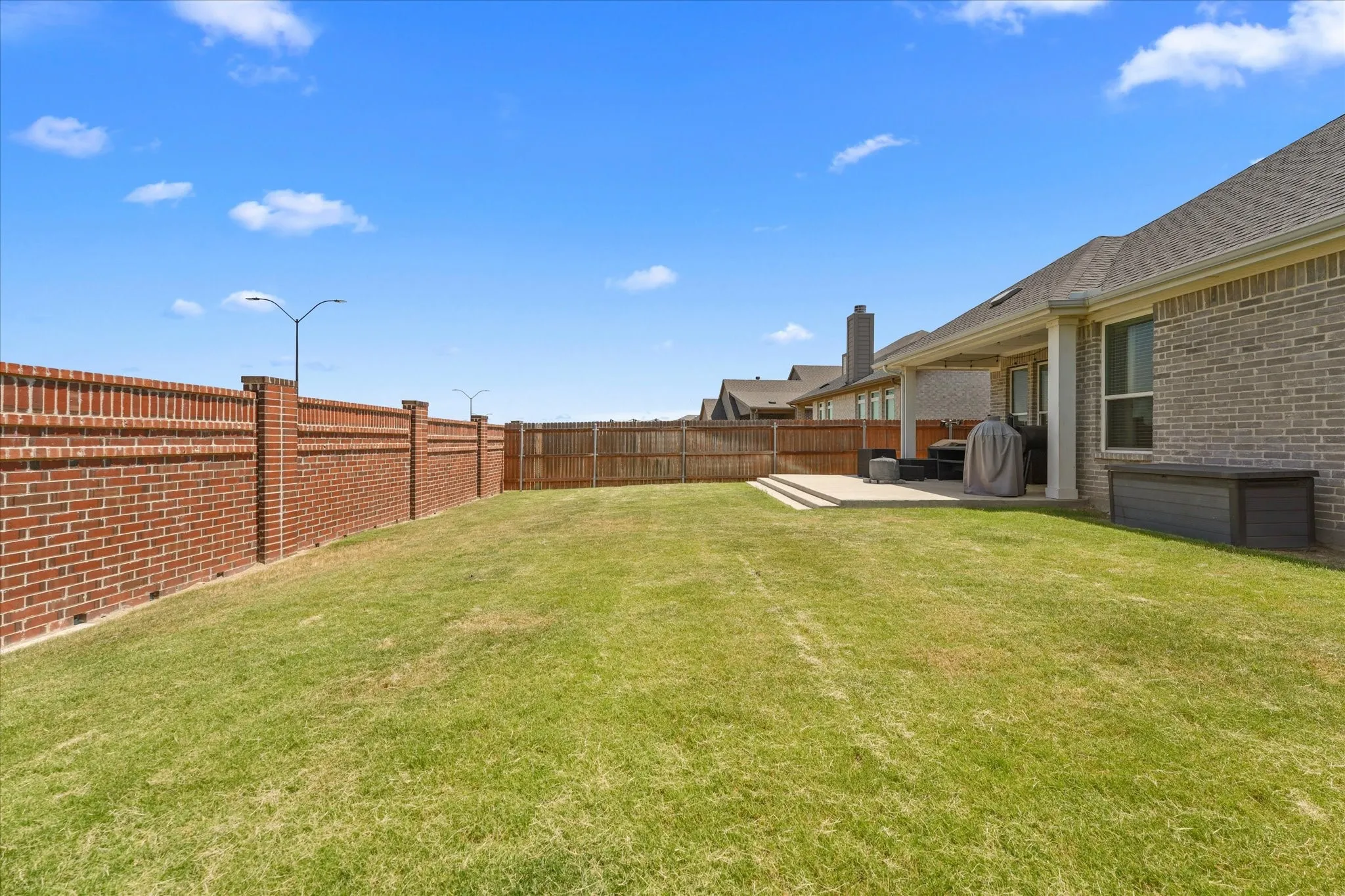 Expansive grassy lawn with a tiered concrete patio