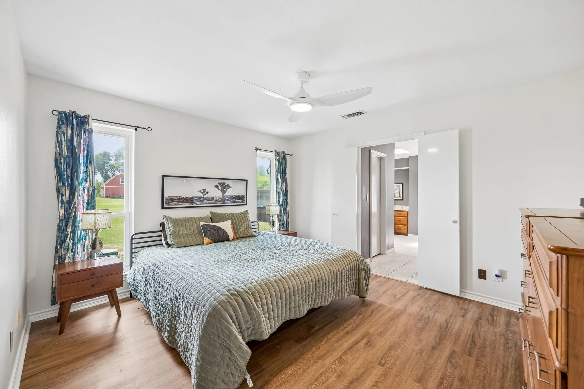 Interior space featuring wood-finish flooring, white walls, and a contemporary ceiling fan