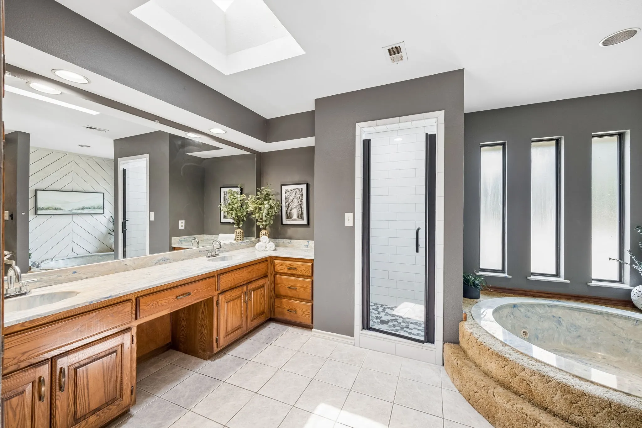 Bathroom featuring a dual vanity with wood cabinetry and light-toned countertops