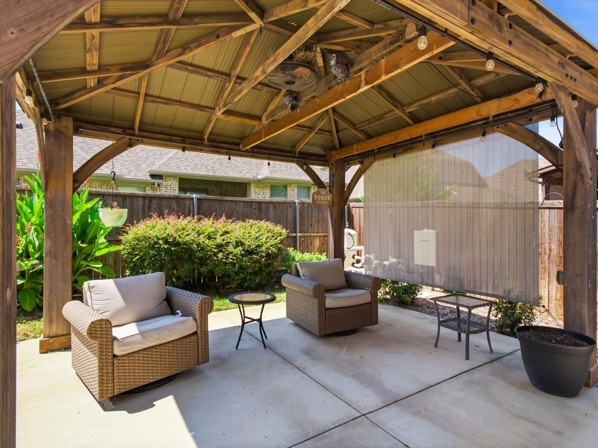 Covered patio with timber beam construction and corrugated metal roofing provides sheltered outdoor entertaining space