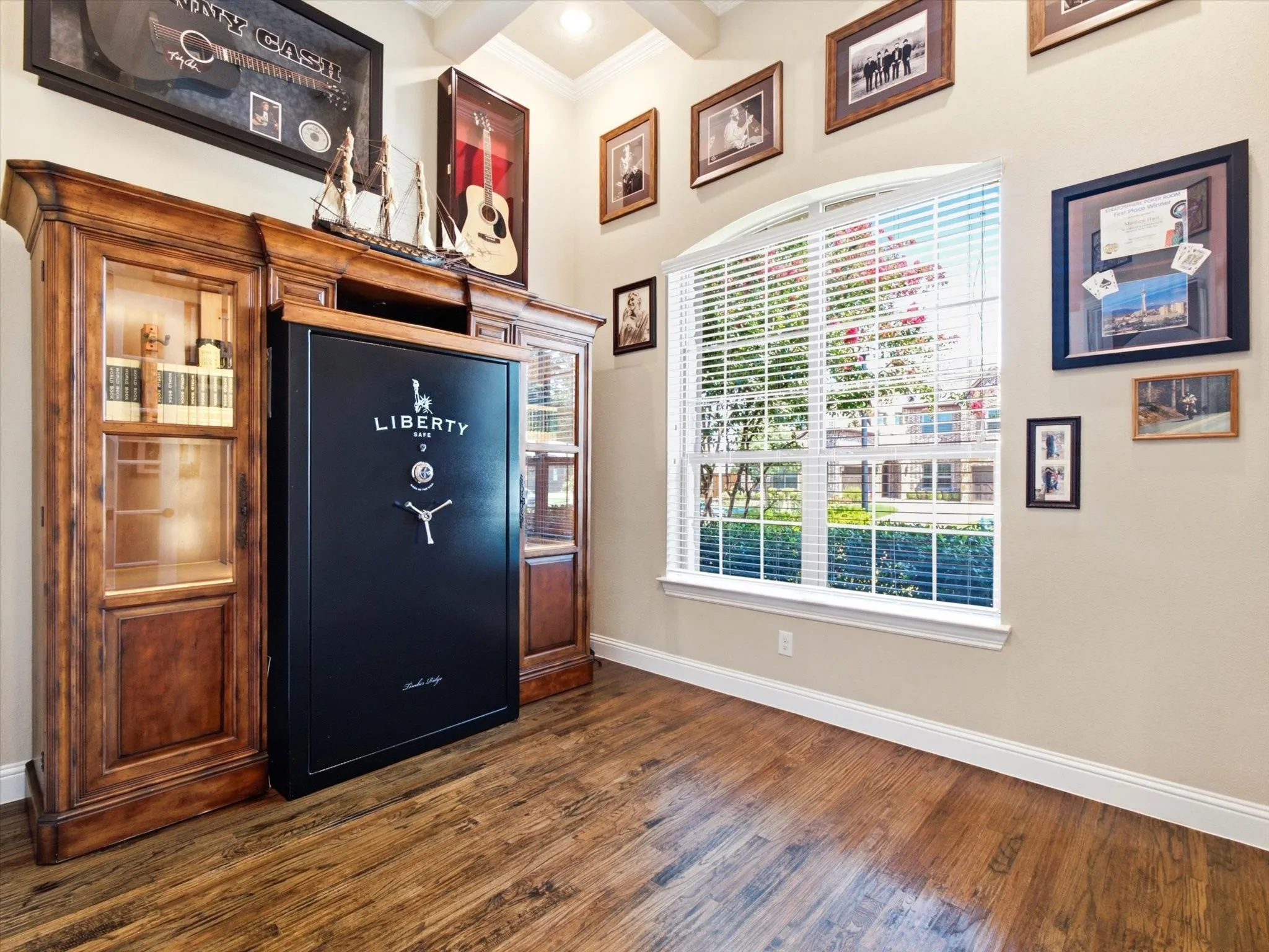 Office with built in cabinets and dark wood floors.