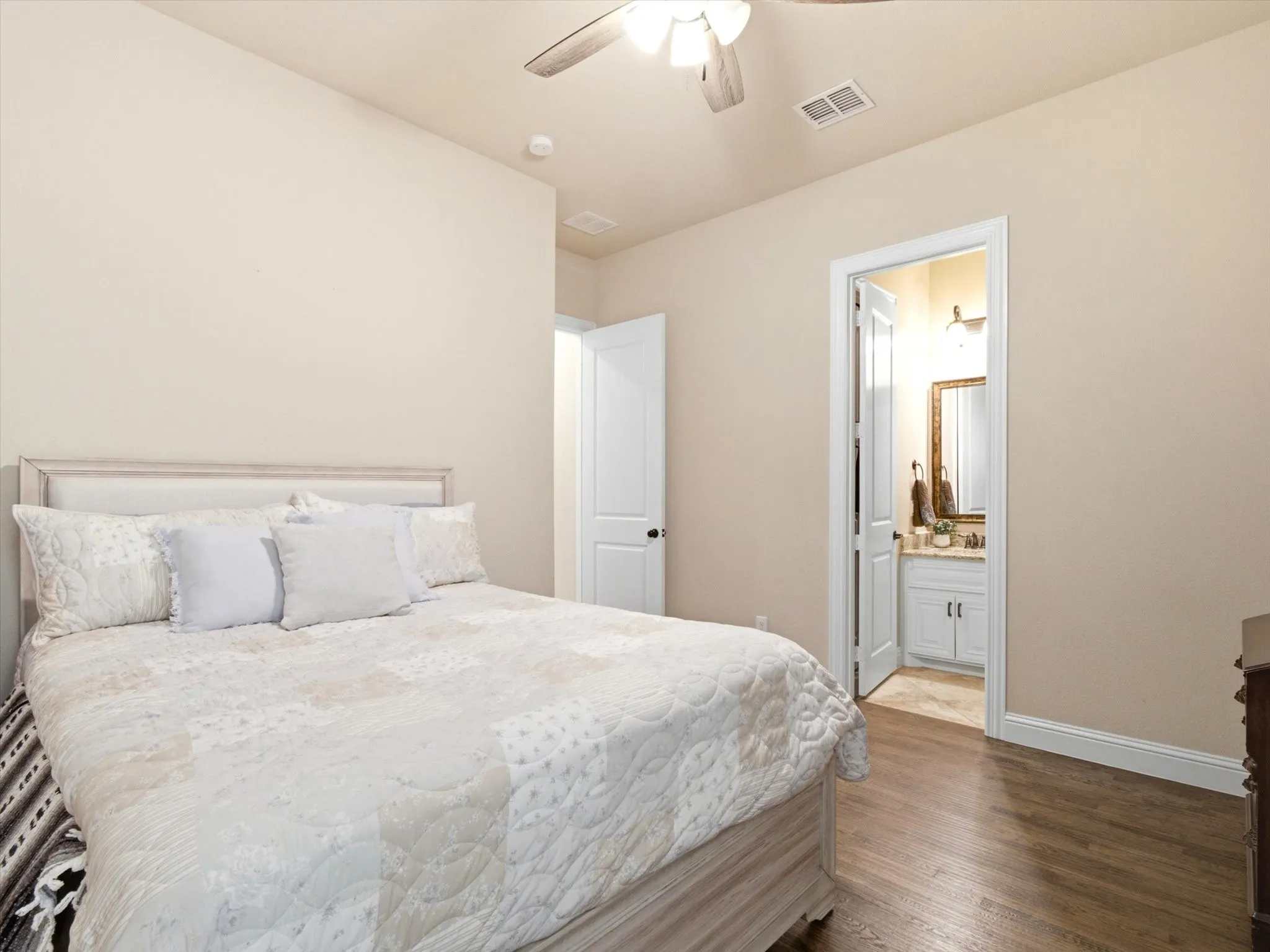 Bedroom featuring wood-finish flooring, a ceiling fan with integrated lighting, and a neutral color palette