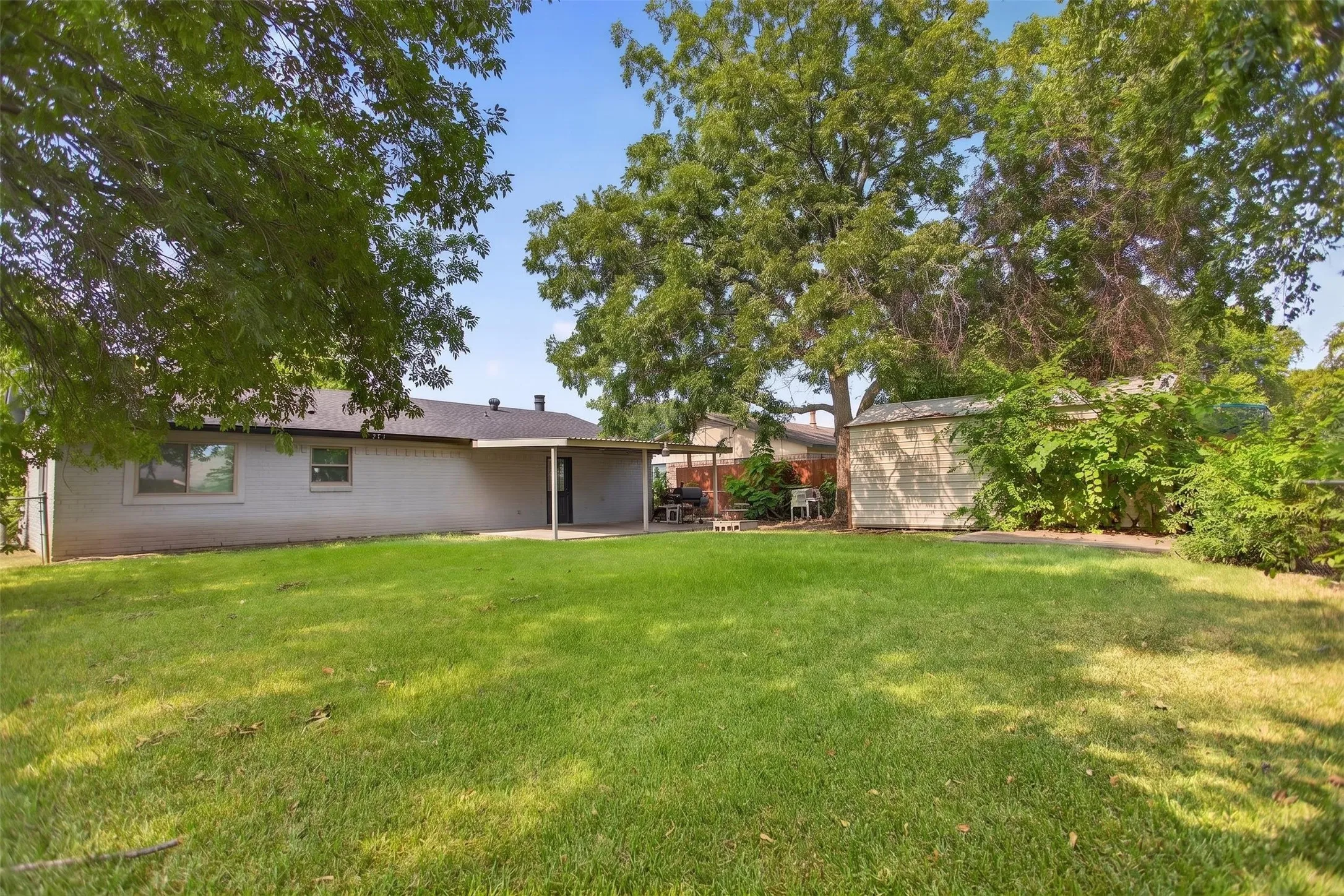 Spacious single-story home set on a generous lot with mature shade trees and manicured lawn