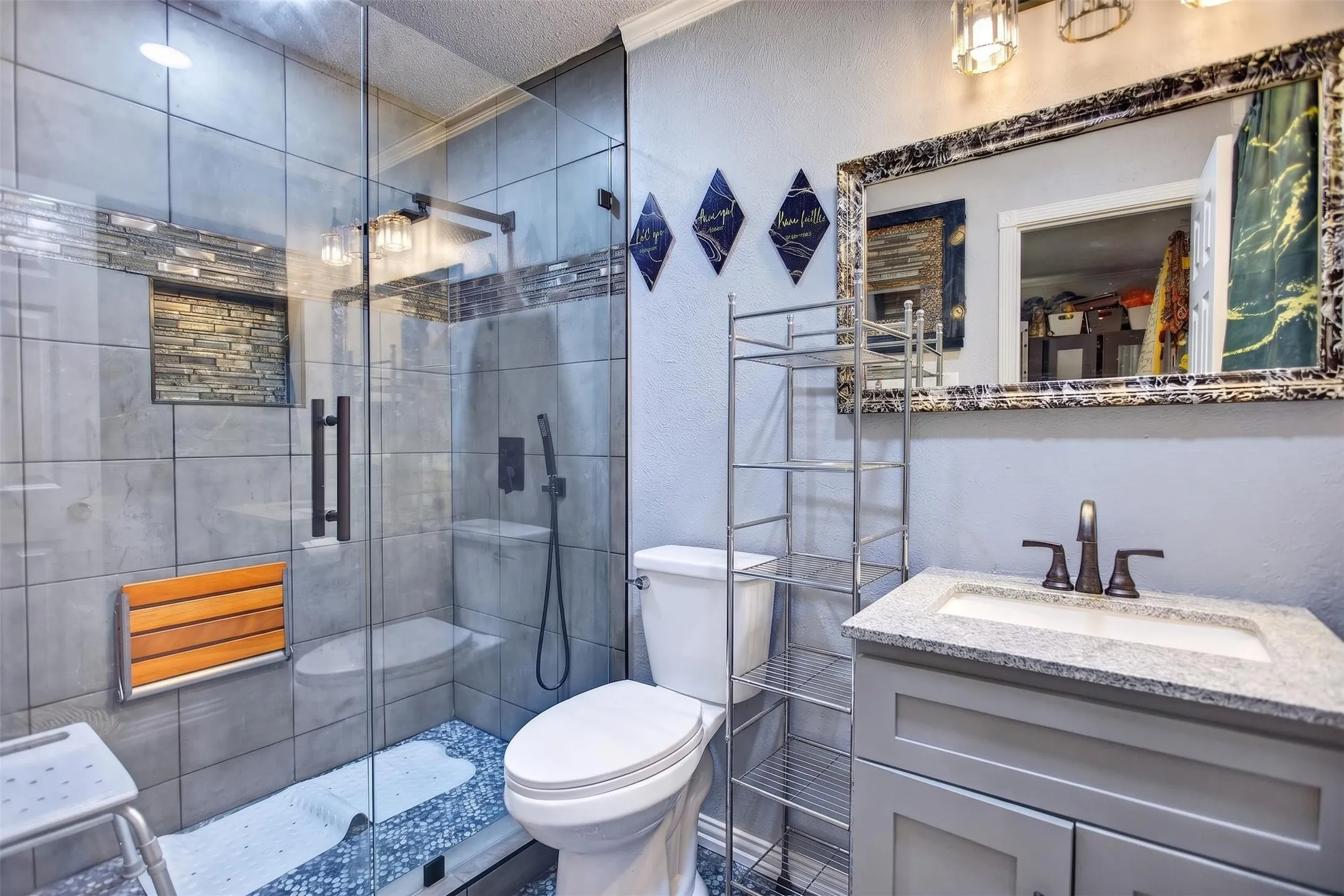 Contemporary bathroom featuring a glass-enclosed shower with grey tile walls and a built-in niche