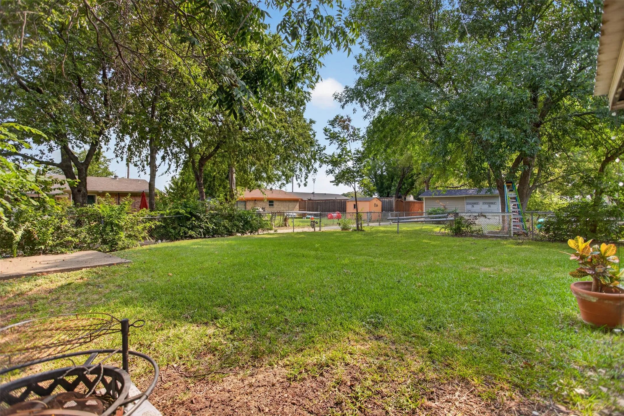 Spacious lawn area framed by mature trees and established perimeter plantings