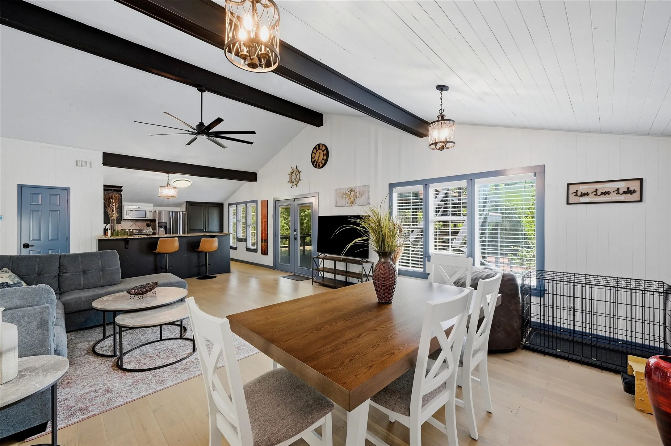 Vaulted ceiling with exposed beams, wood-finish flooring, recessed lighting, and kitchen island with seating