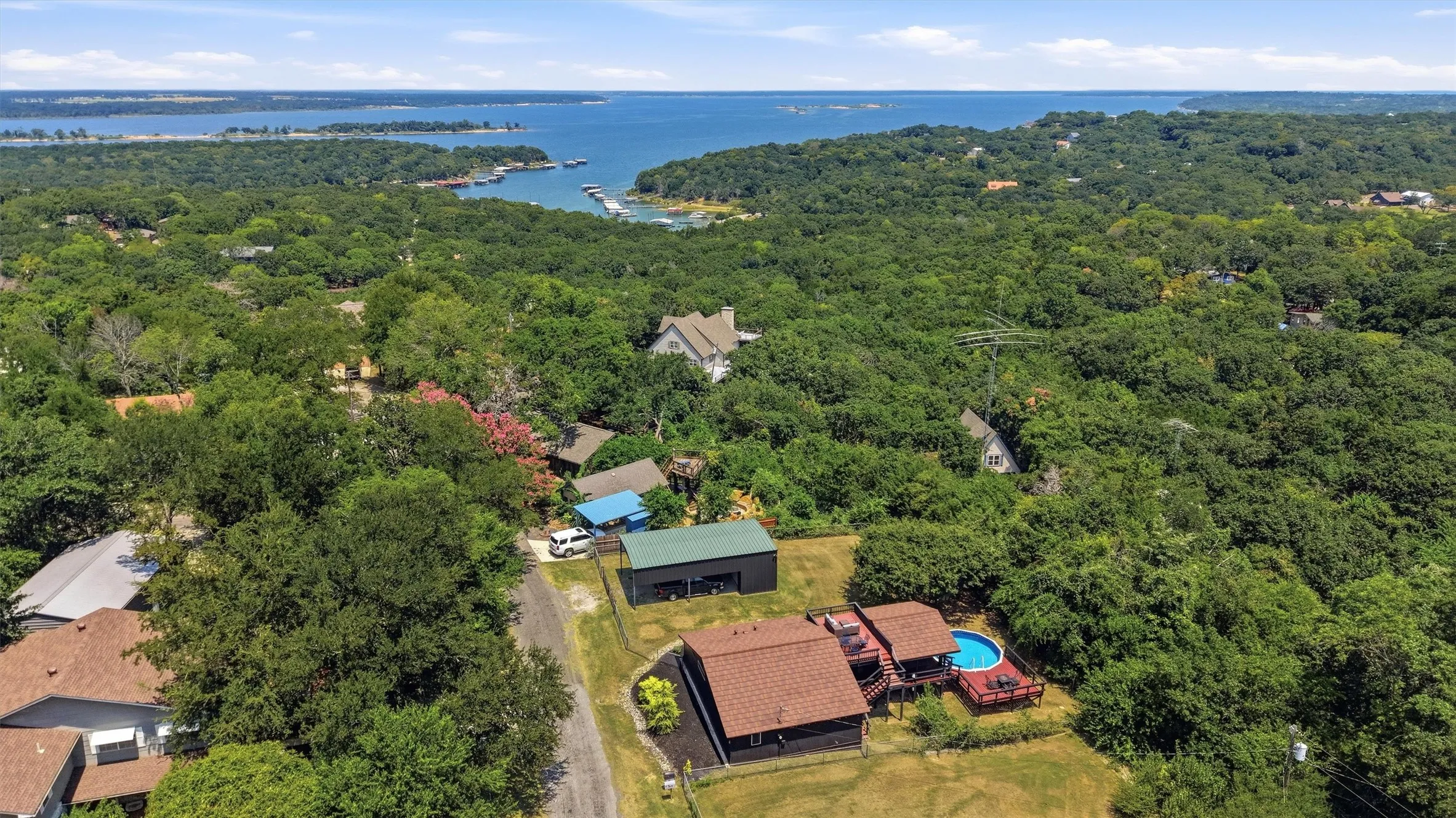 Waterfront community setting with mature trees, residential properties, and a large body of water