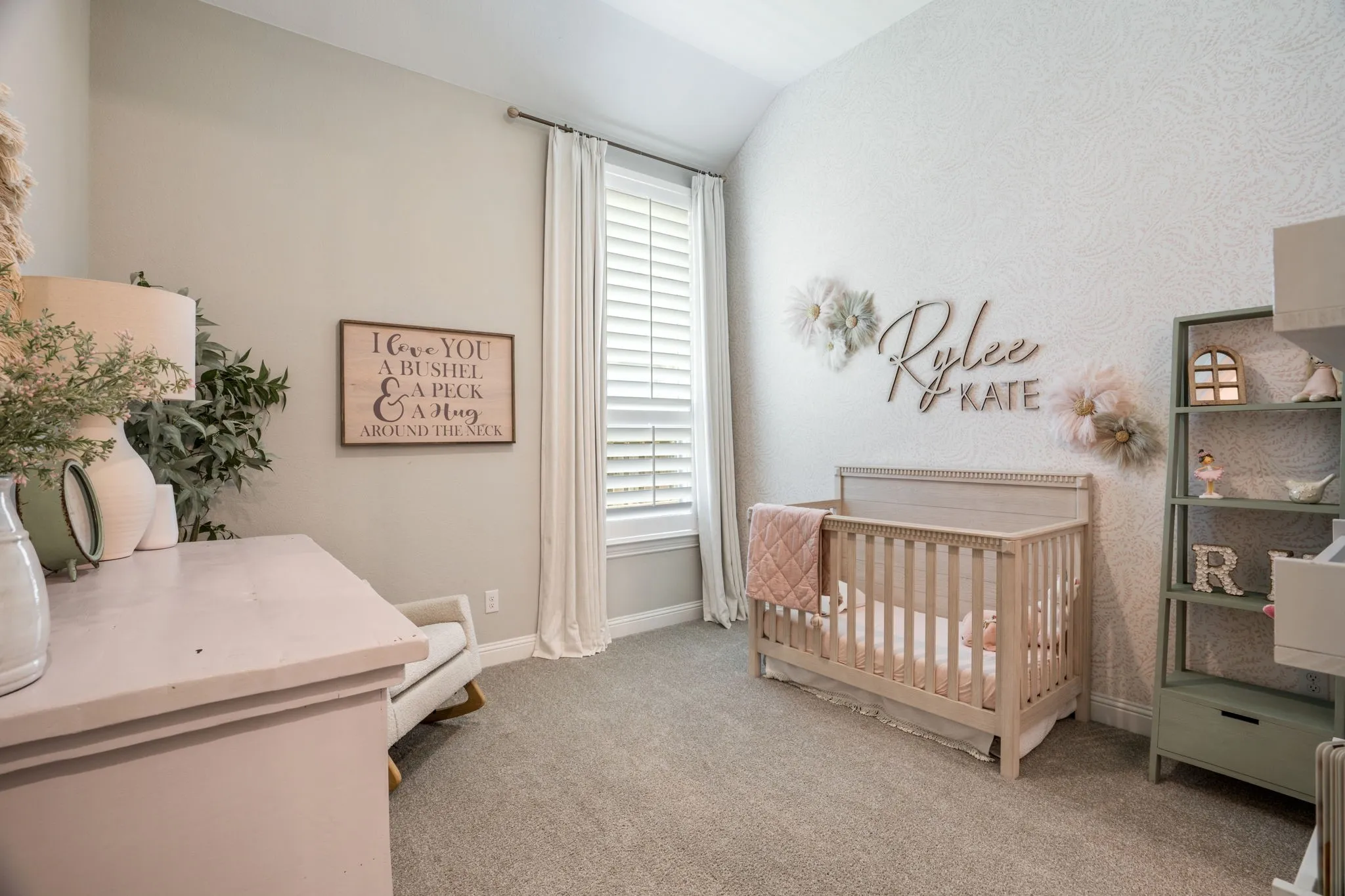 Serene nursery featuring soft neutral tones, carpet flooring, and ample natural light from shuttered windows