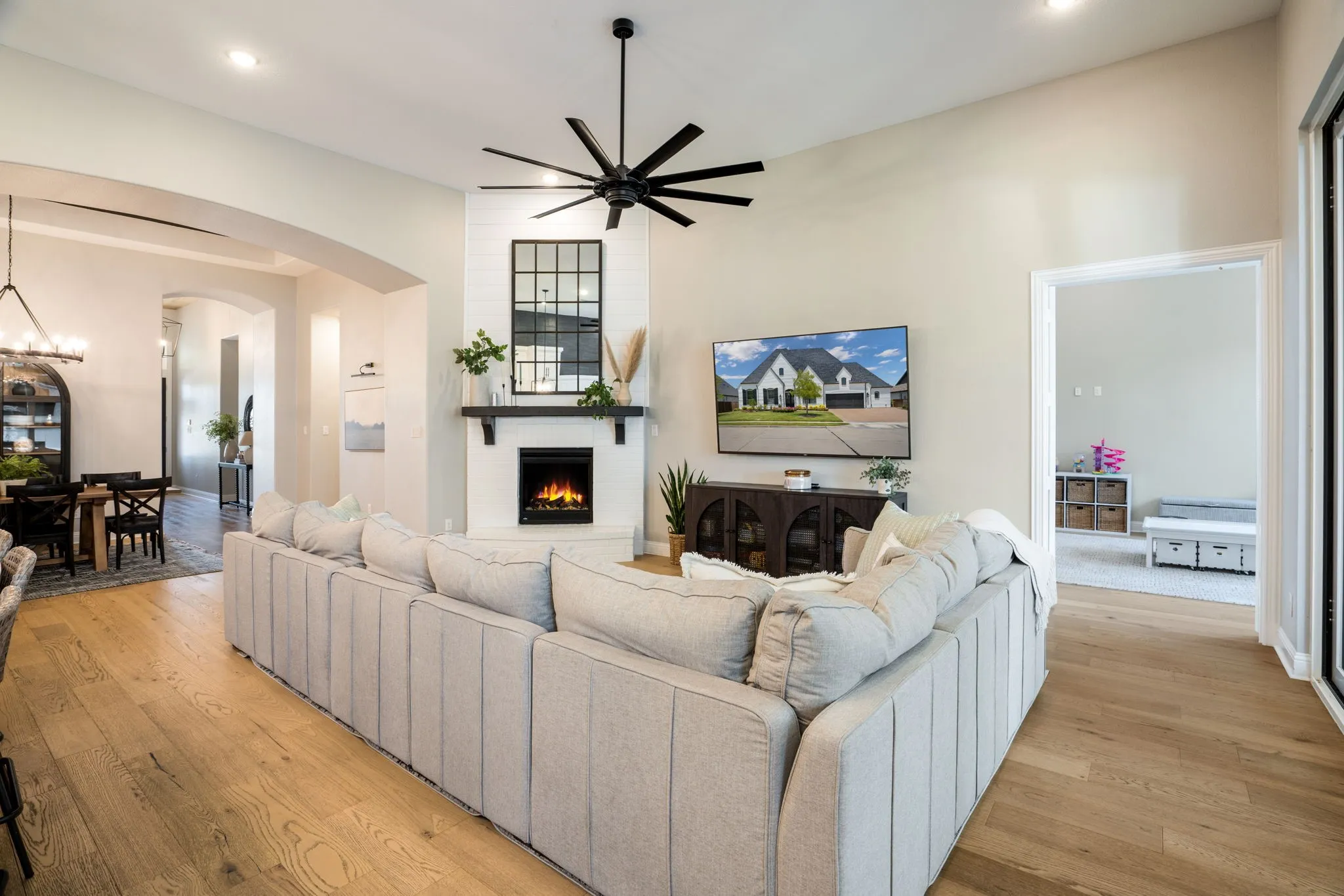 Spacious living room anchored by a fireplace with built-in surround cabinetry and a wood-finish mantel, complemented by large-scale sectional seating