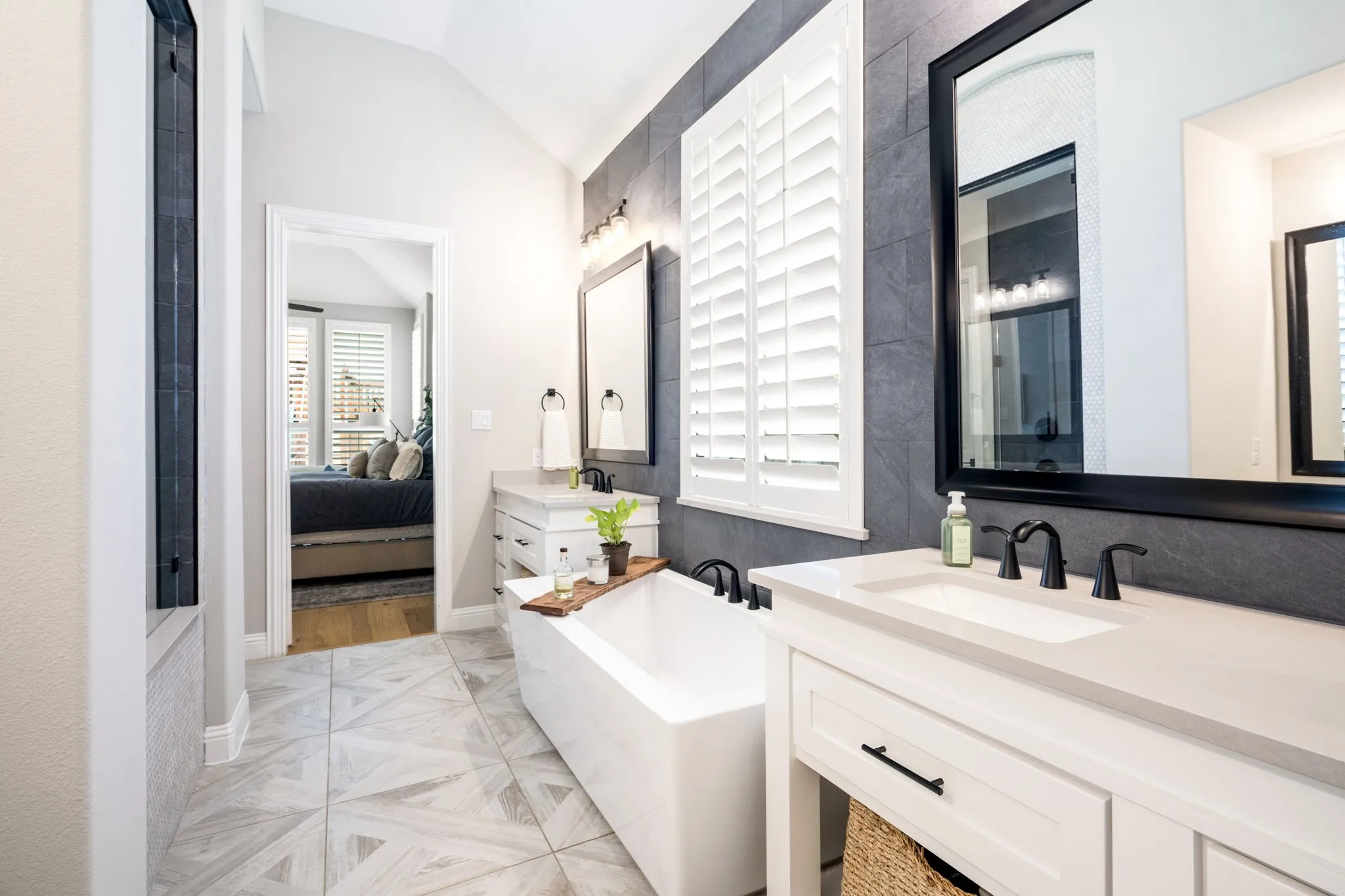 Spa-inspired primary bathroom featuring dual vanities with white cabinetry, rectangular vessel sinks, and matte black hardware