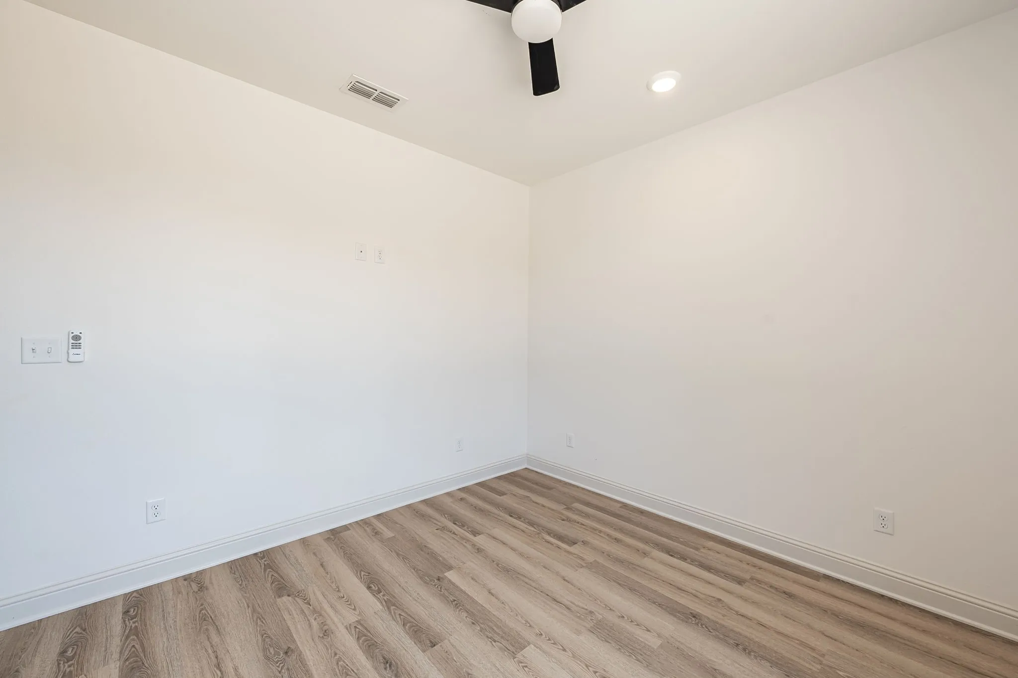 Wood-finish flooring, recessed ceiling lighting, and a ceiling fan with light fixture