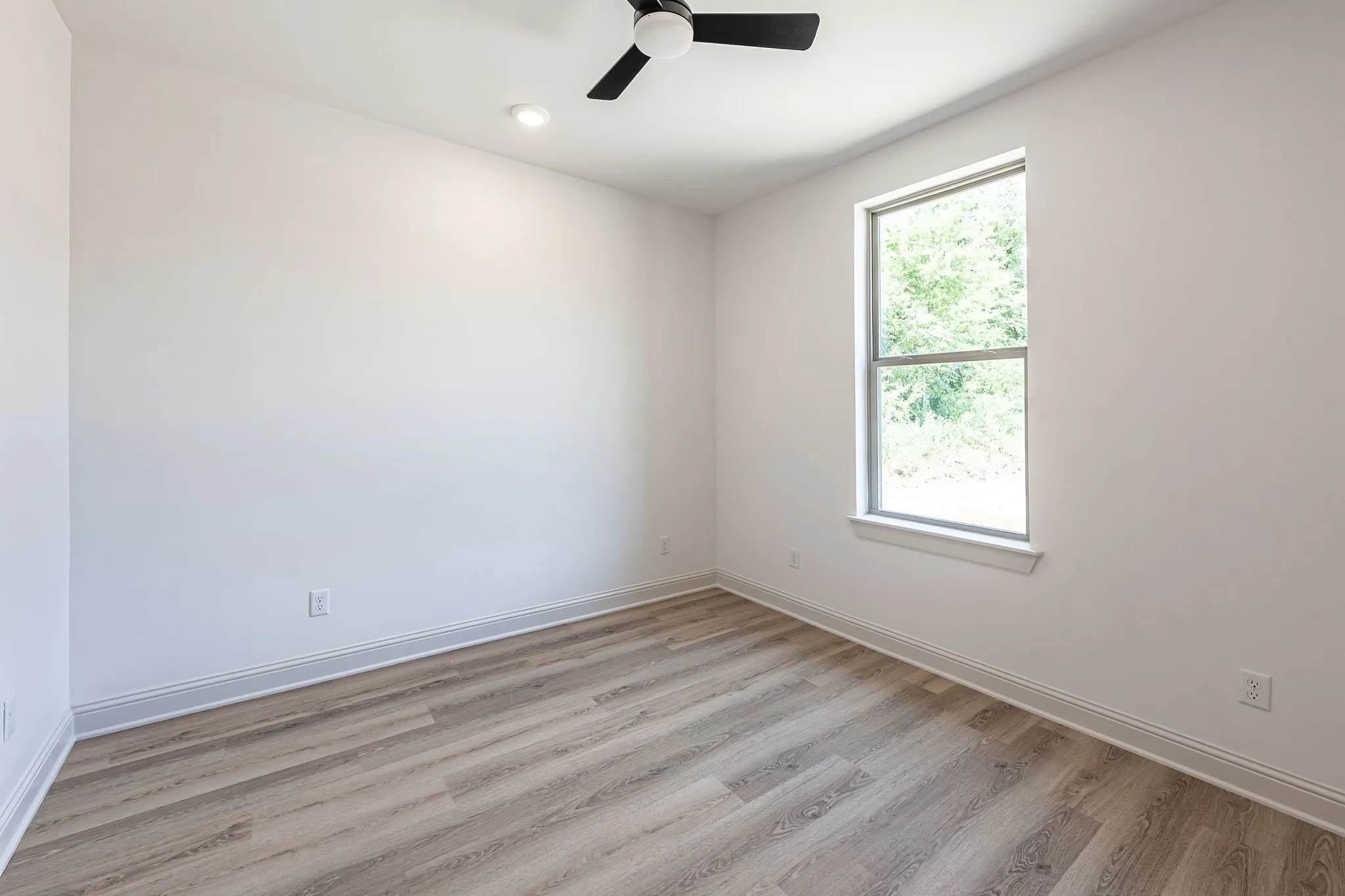 Neutral wall paint, wood-finish flooring, single window, contemporary ceiling fan, recessed lighting