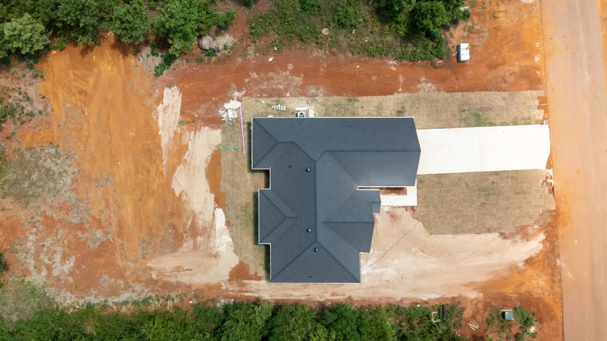 New construction residence featuring a dark shingle roof and a concrete driveway