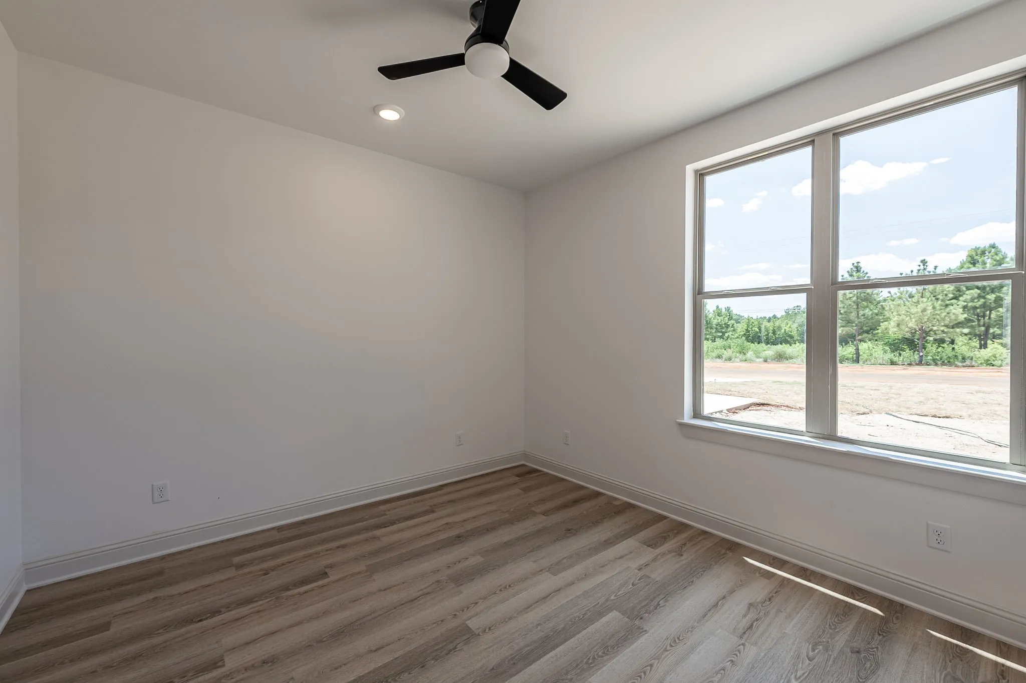 Large window, wood-finish flooring, recessed lighting, and a ceiling fan