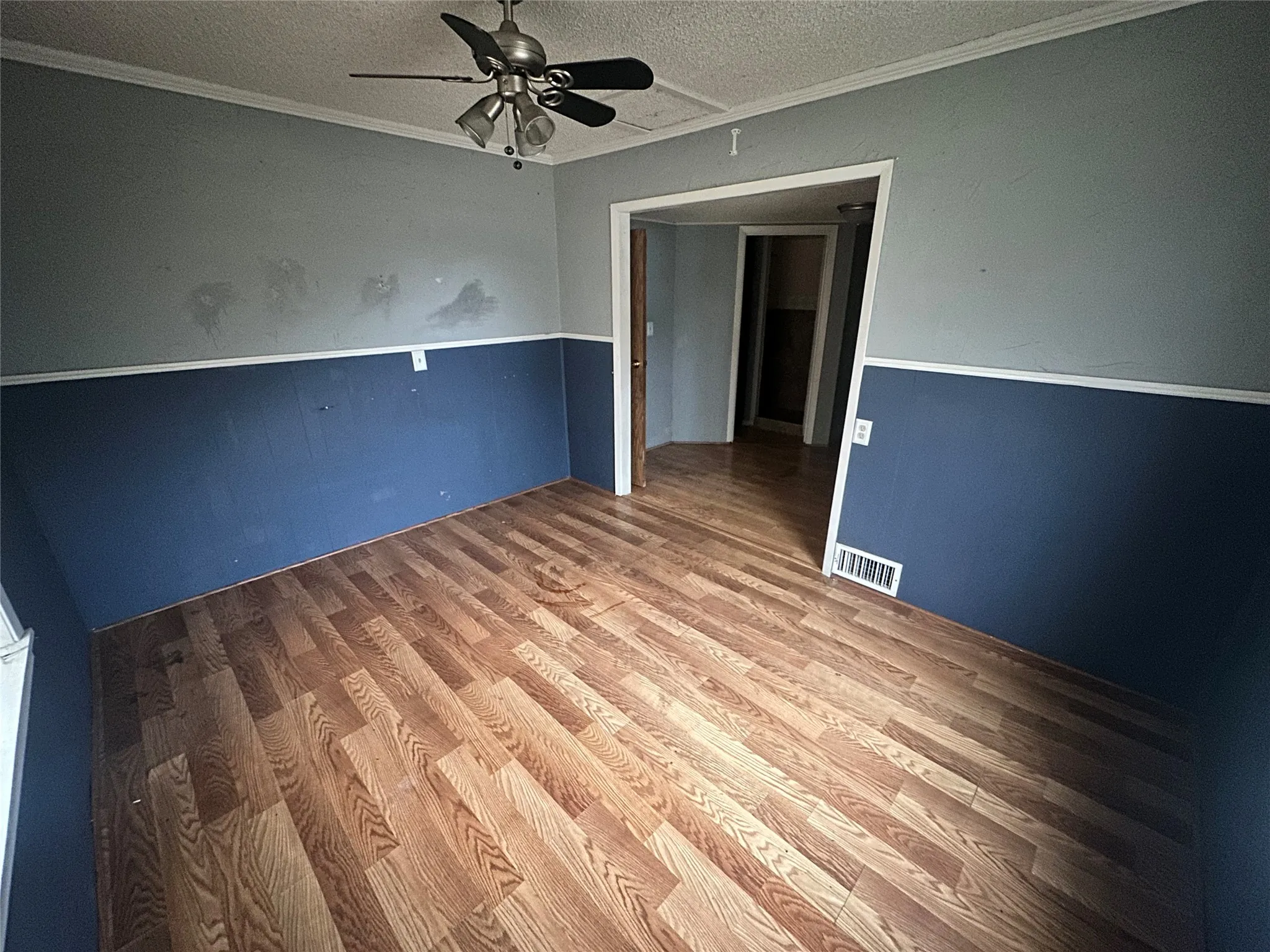 Unfurnished room featuring crown molding, hardwood / wood-style floors, a textured ceiling, and ceiling fan