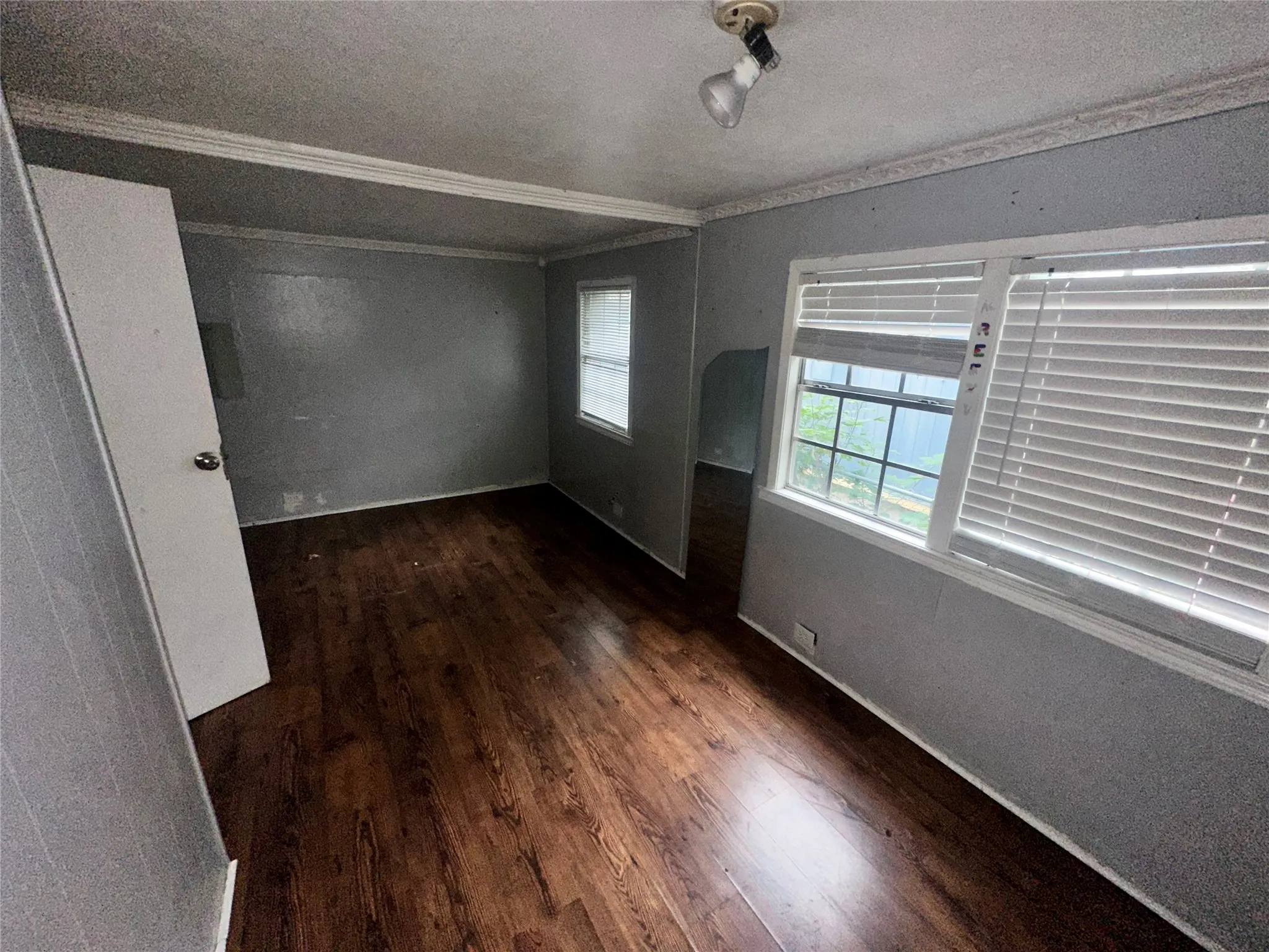 Spare room with ornamental molding, dark hardwood / wood-style floors, and a textured ceiling