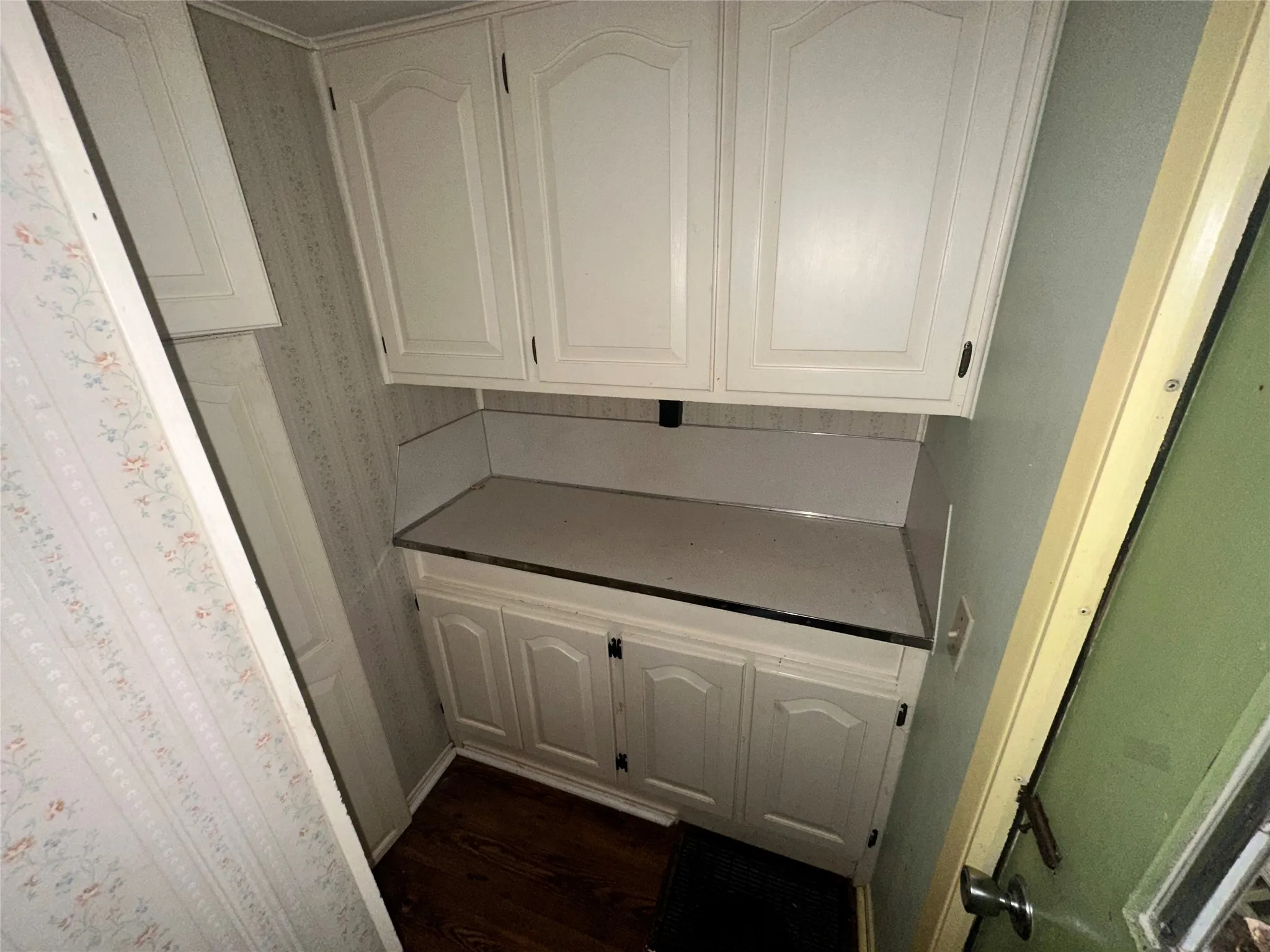 Kitchen with white cabinetry and dark hardwood / wood-style flooring