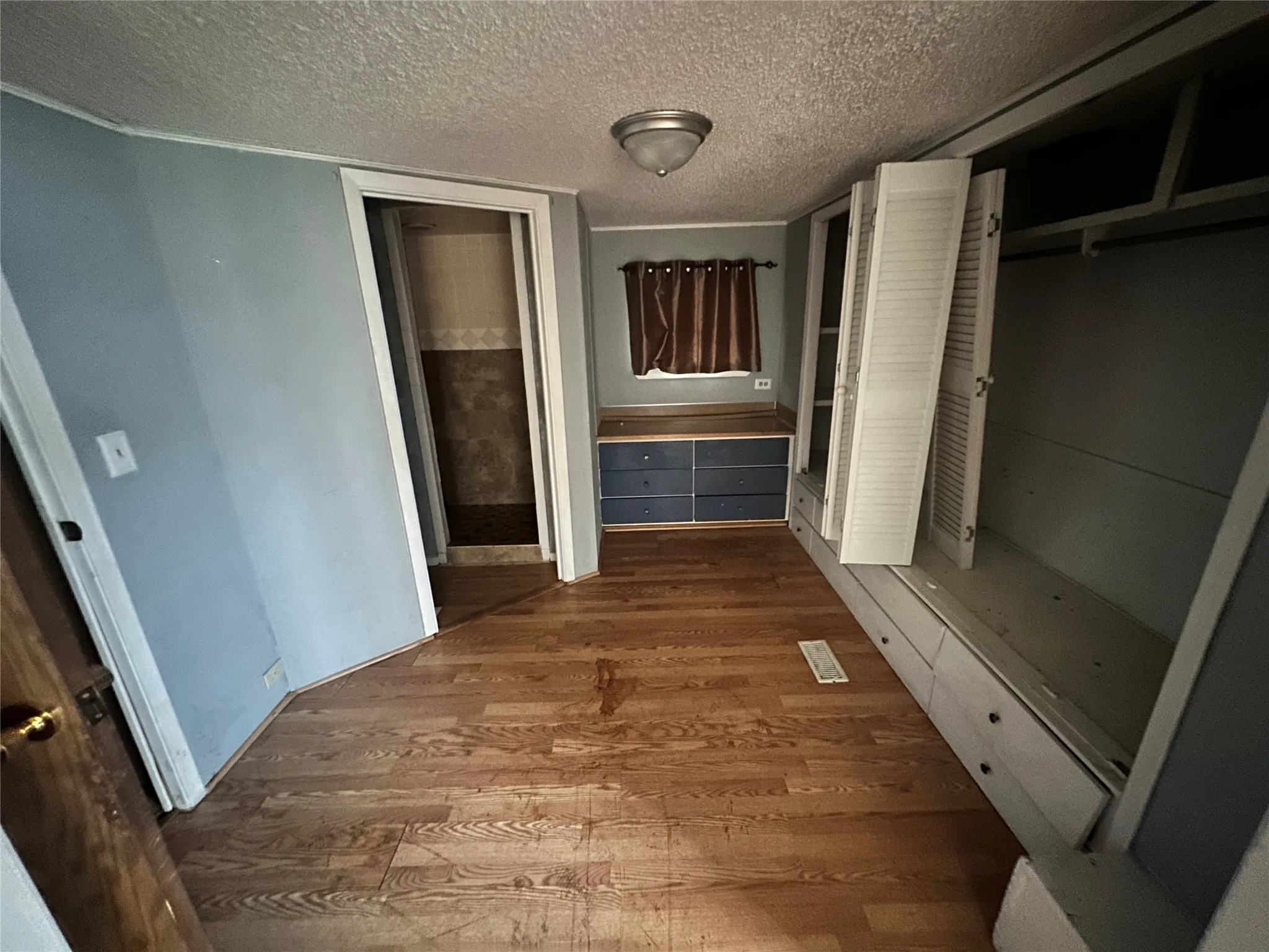 Hallway featuring a textured ceiling and wood-type flooring