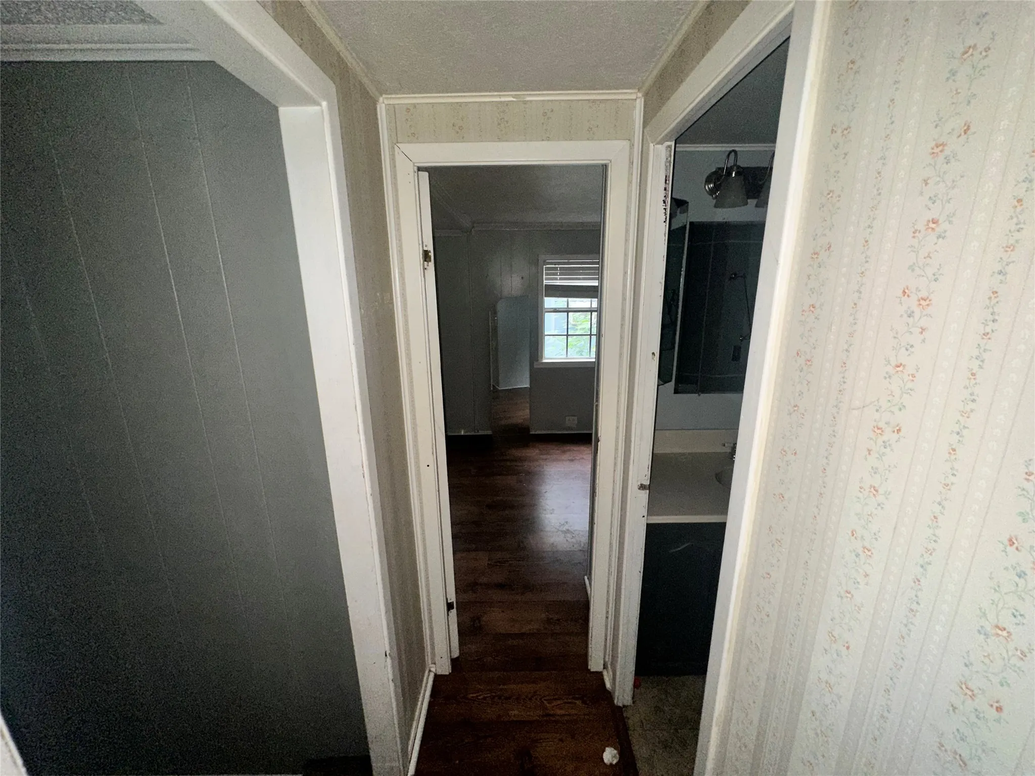 Corridor with dark wood-type flooring and crown molding