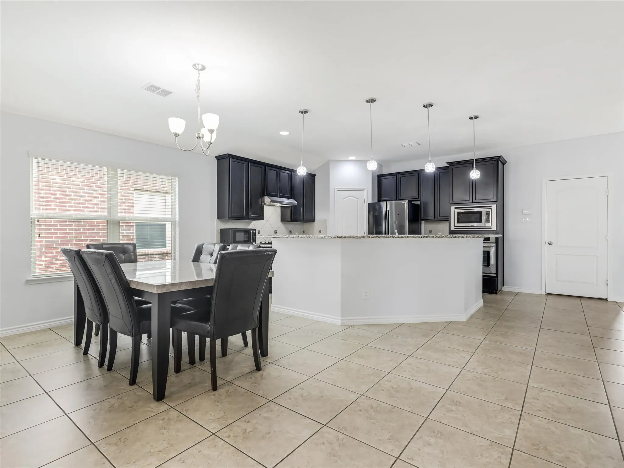 Open-concept kitchen and dining area with tile flooring