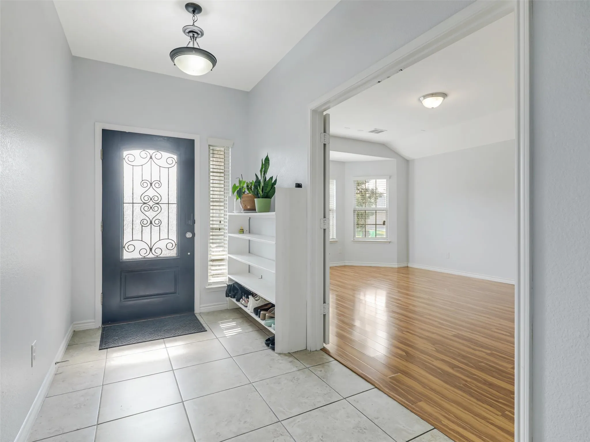 Entryway featuring light tile flooring and a dark entry door with decorative ironwork