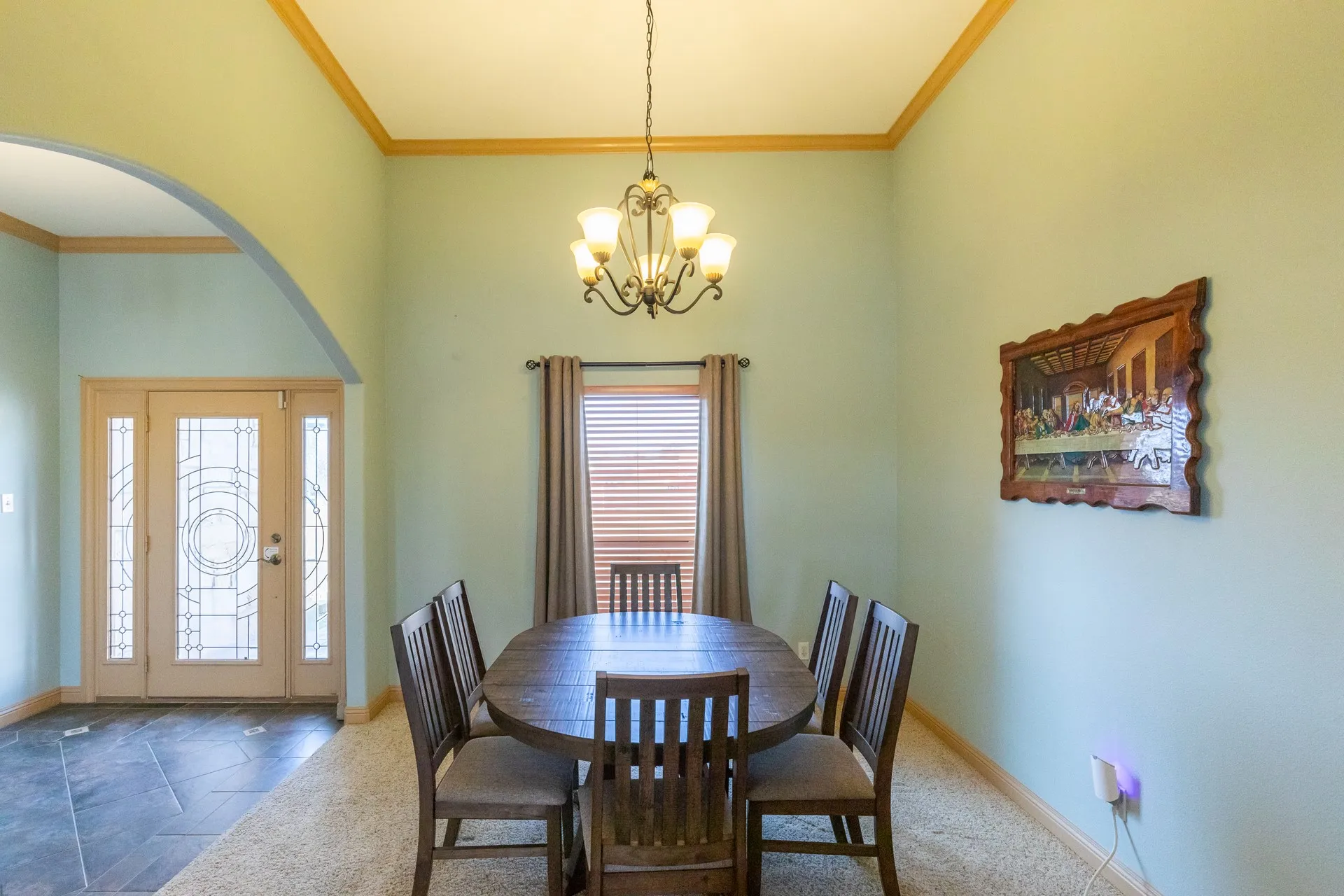 Formal dining space featuring high ceilings with crown molding and a decorative chandelier