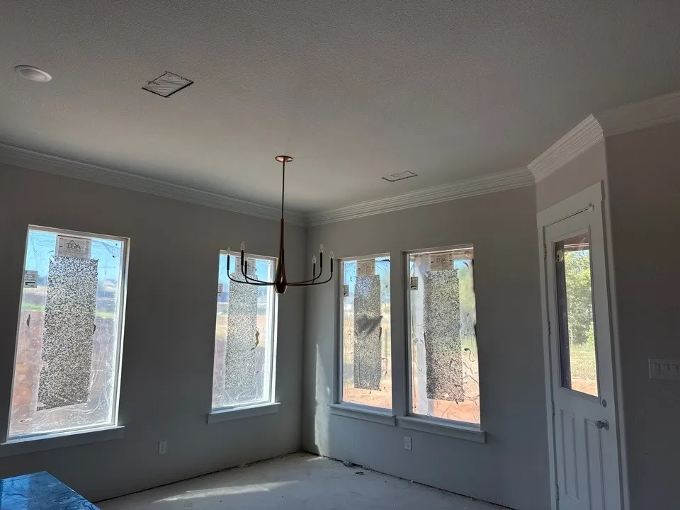 Bright, light-filled room showcasing multiple large windows with natural sightlines to exterior landscape, recessed ceiling lighting, and neutral wall finishes