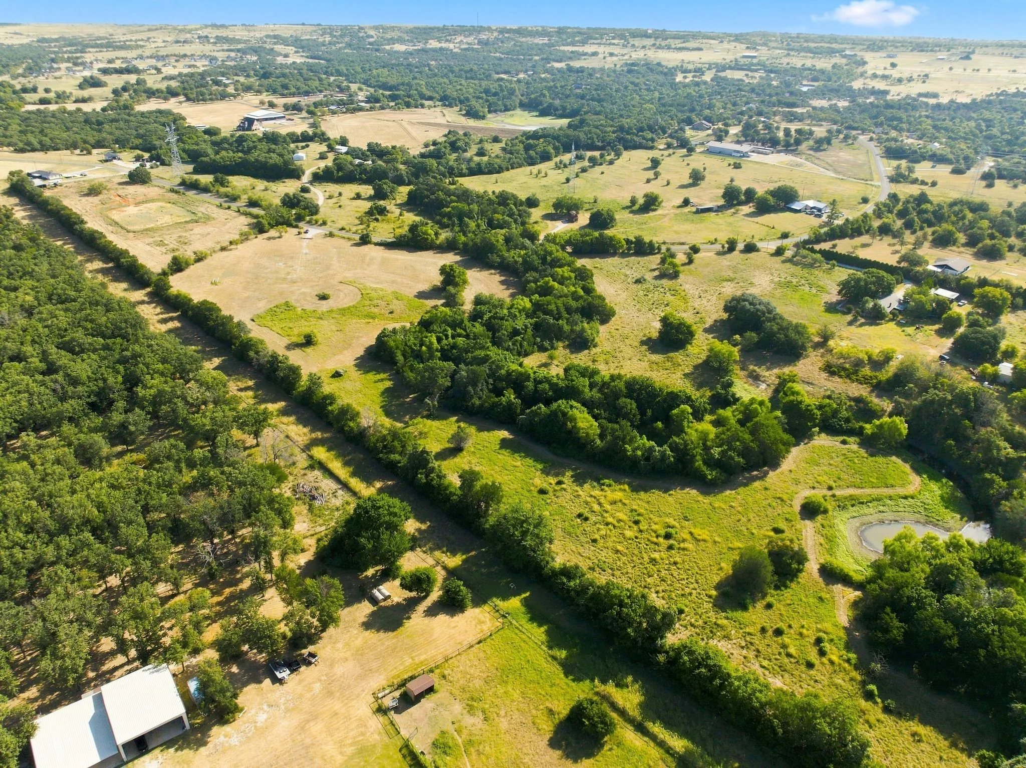 Expansive rural property featuring rolling pastureland with mature tree clusters, established hedgerow divisions, and productive grazing acreage