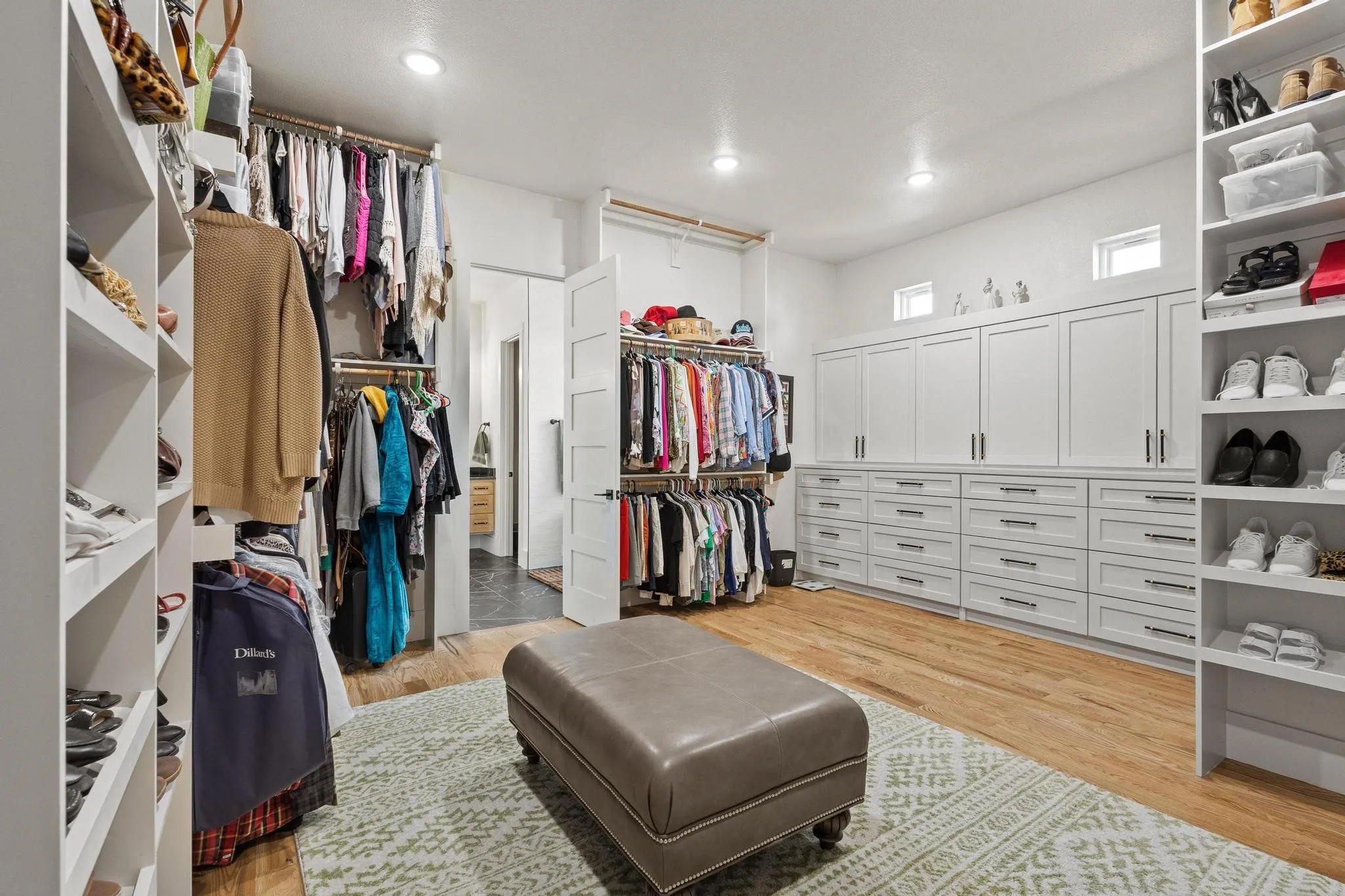 Custom built-in cabinetry with ample storage, featuring wood-finish flooring, recessed lighting, and dedicated shoe shelving