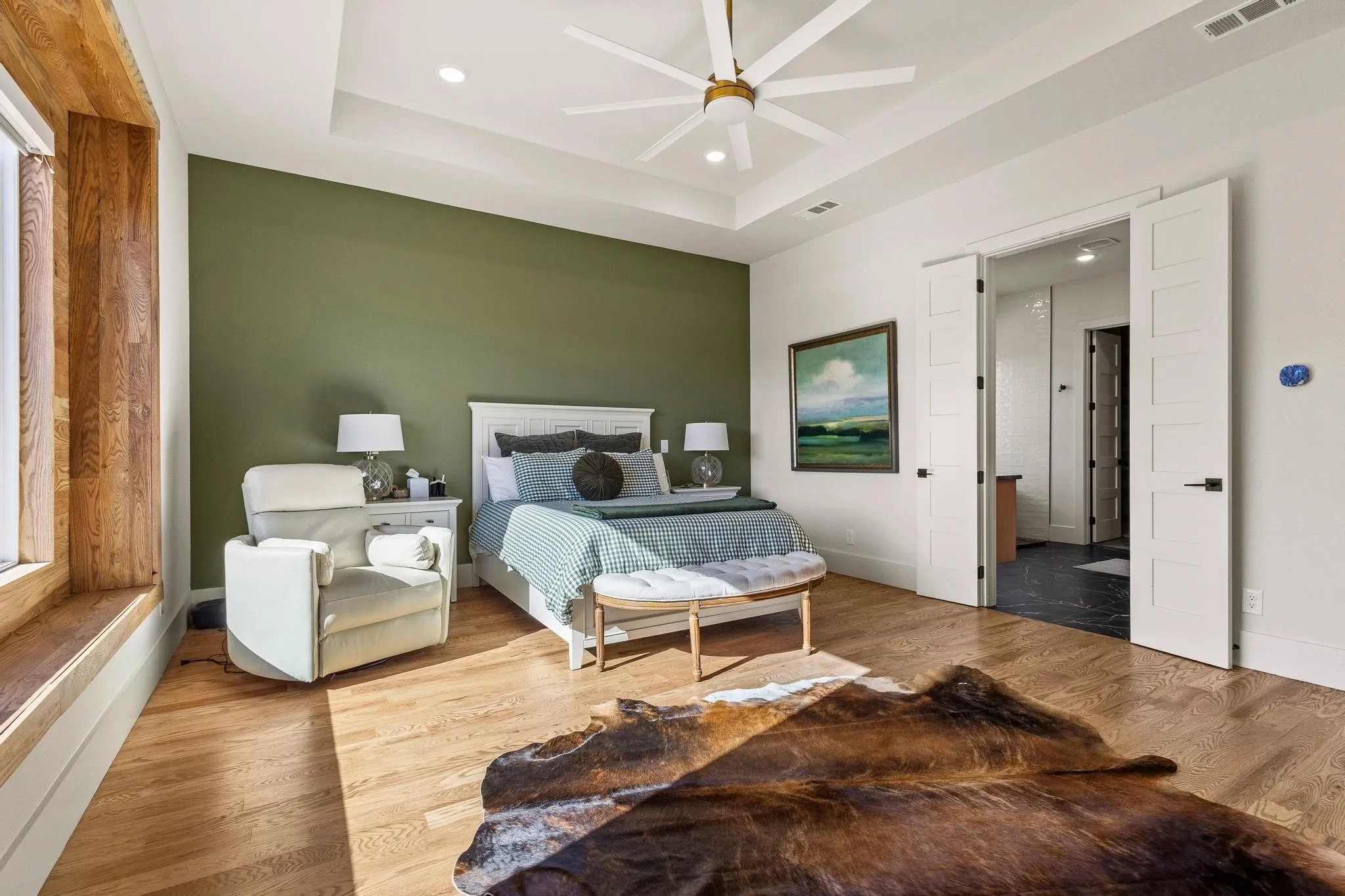 Spacious room featuring wood-finish flooring, a tray ceiling with a ceiling fan, recessed lighting, and a window with wood paneling