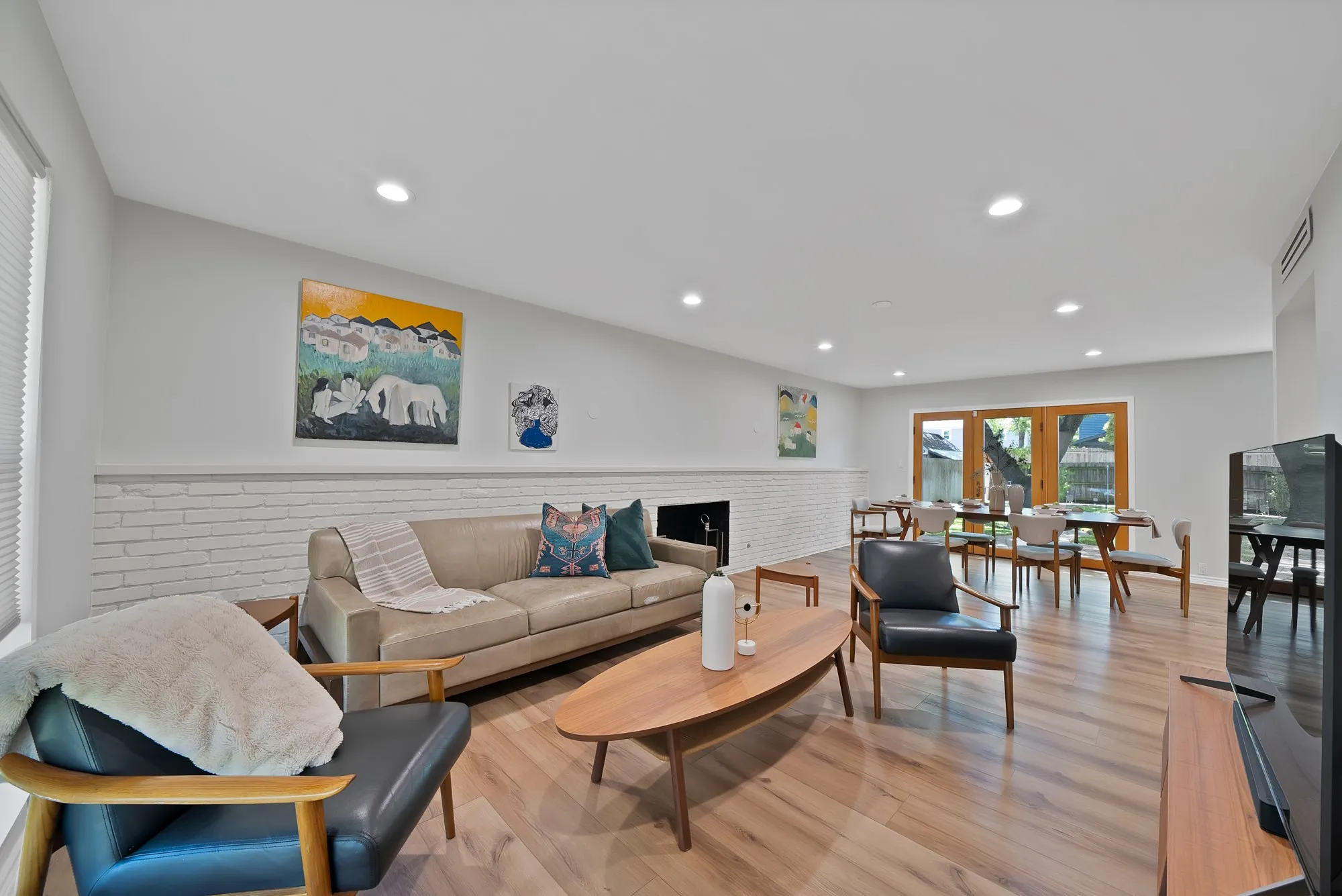 Open-concept living area featuring hardwood flooring, recessed ceiling lighting, and a neutral color palette