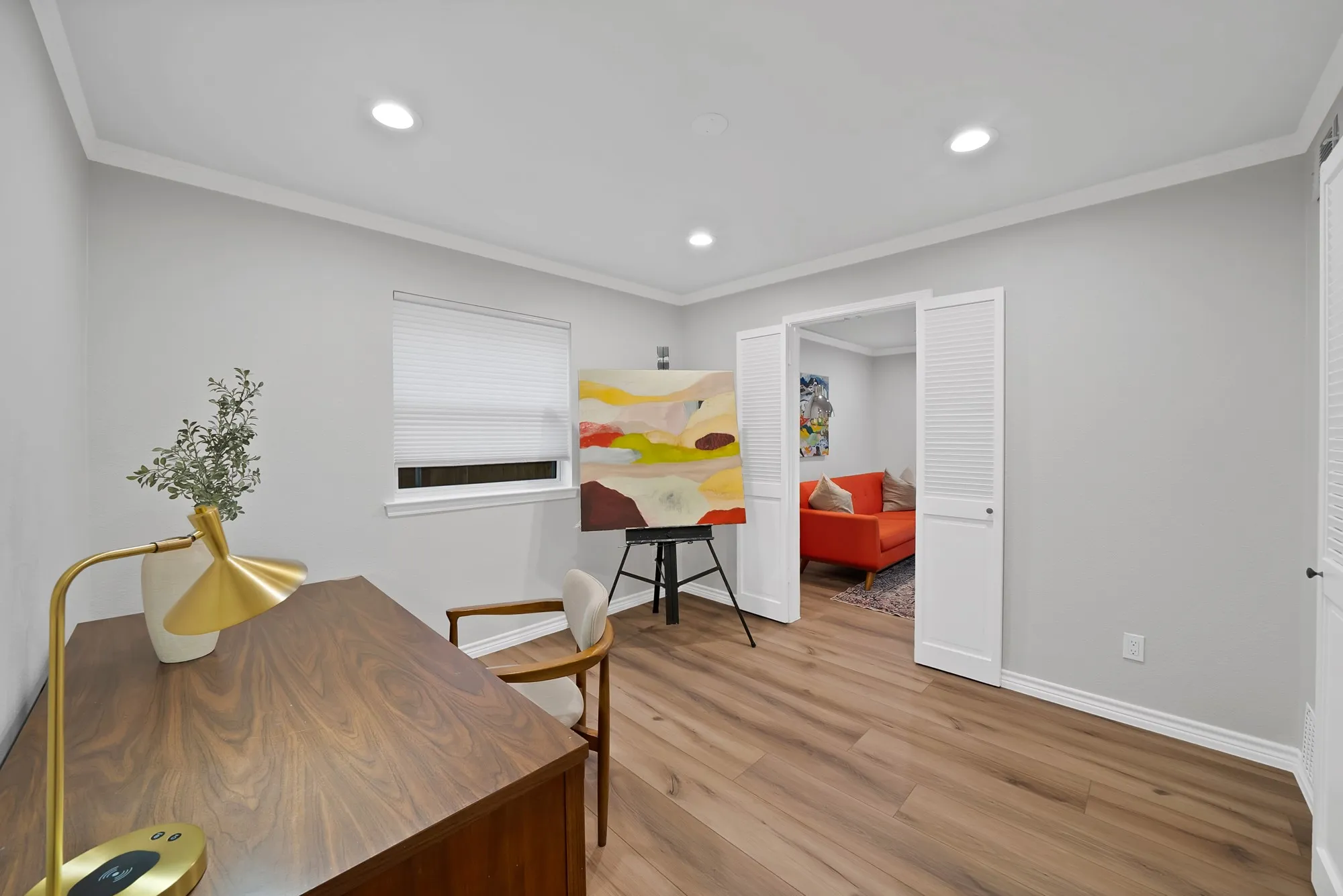 Recessed lighting, crown molding, wood-finish flooring, and white louvered bifold doors