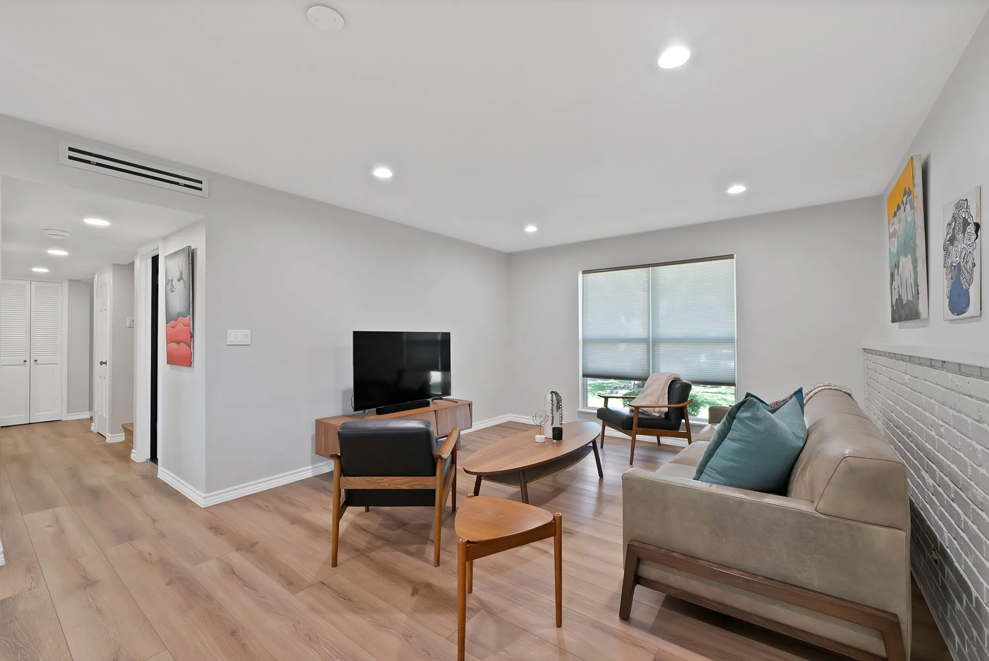 Recessed lighting illuminates wood-finish flooring throughout