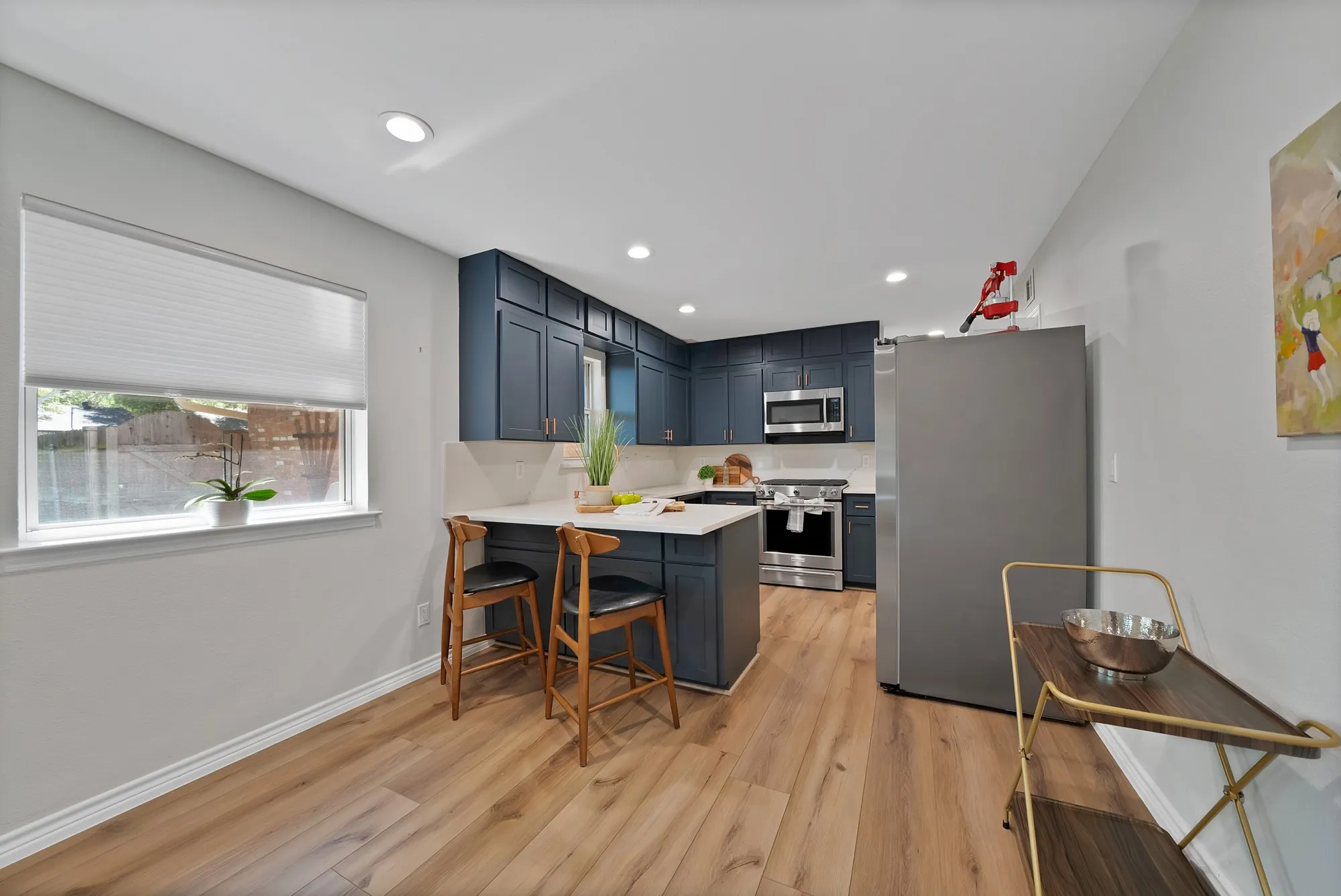 Kitchen featuring blue cabinetry, white countertops, wood-finish flooring, stainless steel appliances, and recessed lighting